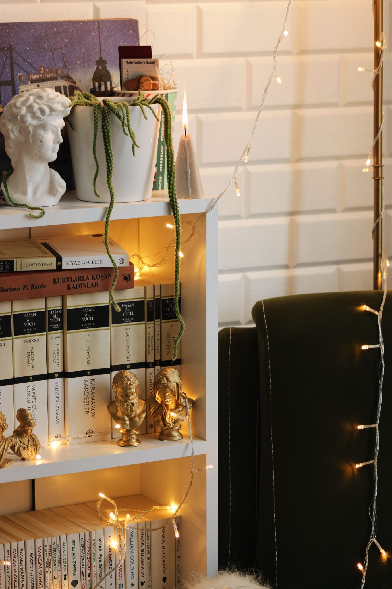 A stylish bookshelf adorned with books and fairy lights, creating a cozy home decor vibe.