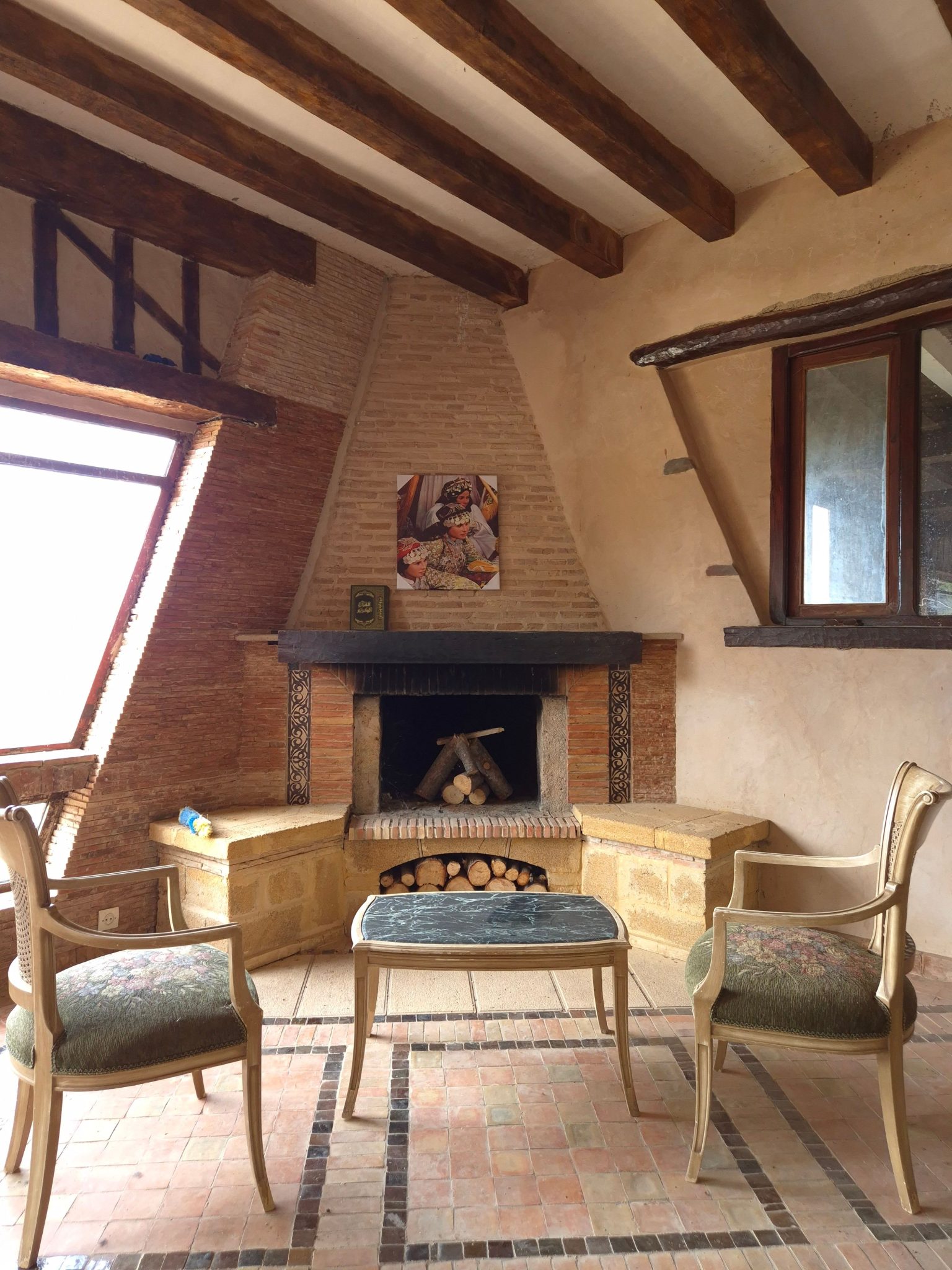 A warm, inviting rustic living room featuring a fireplace and vintage furniture.