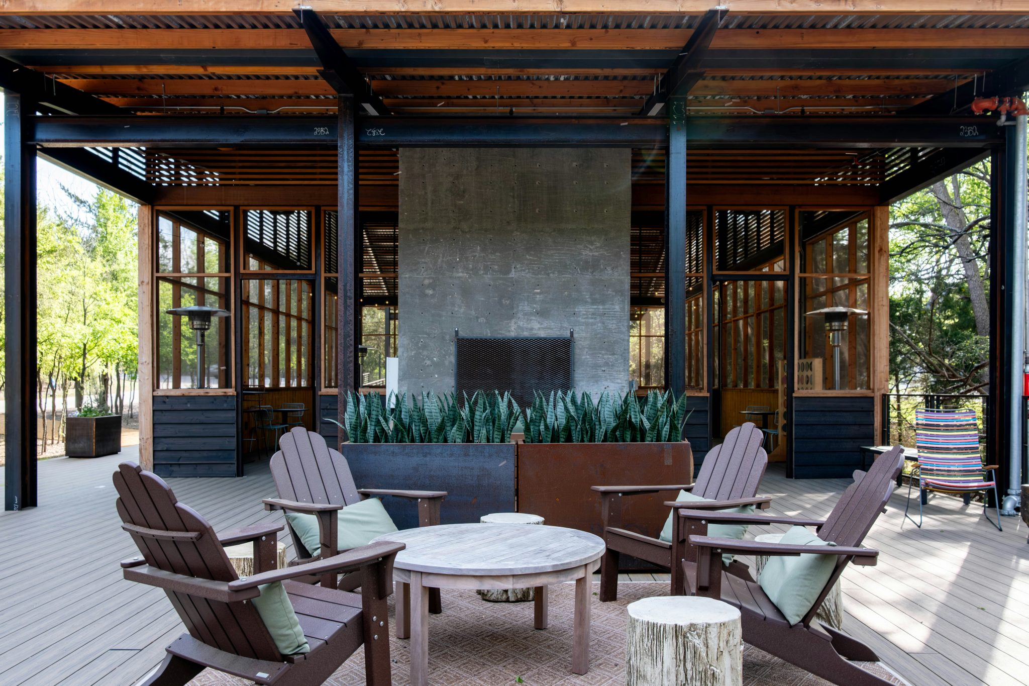 An outdoor patio with a fireplace and adirondack chairs
