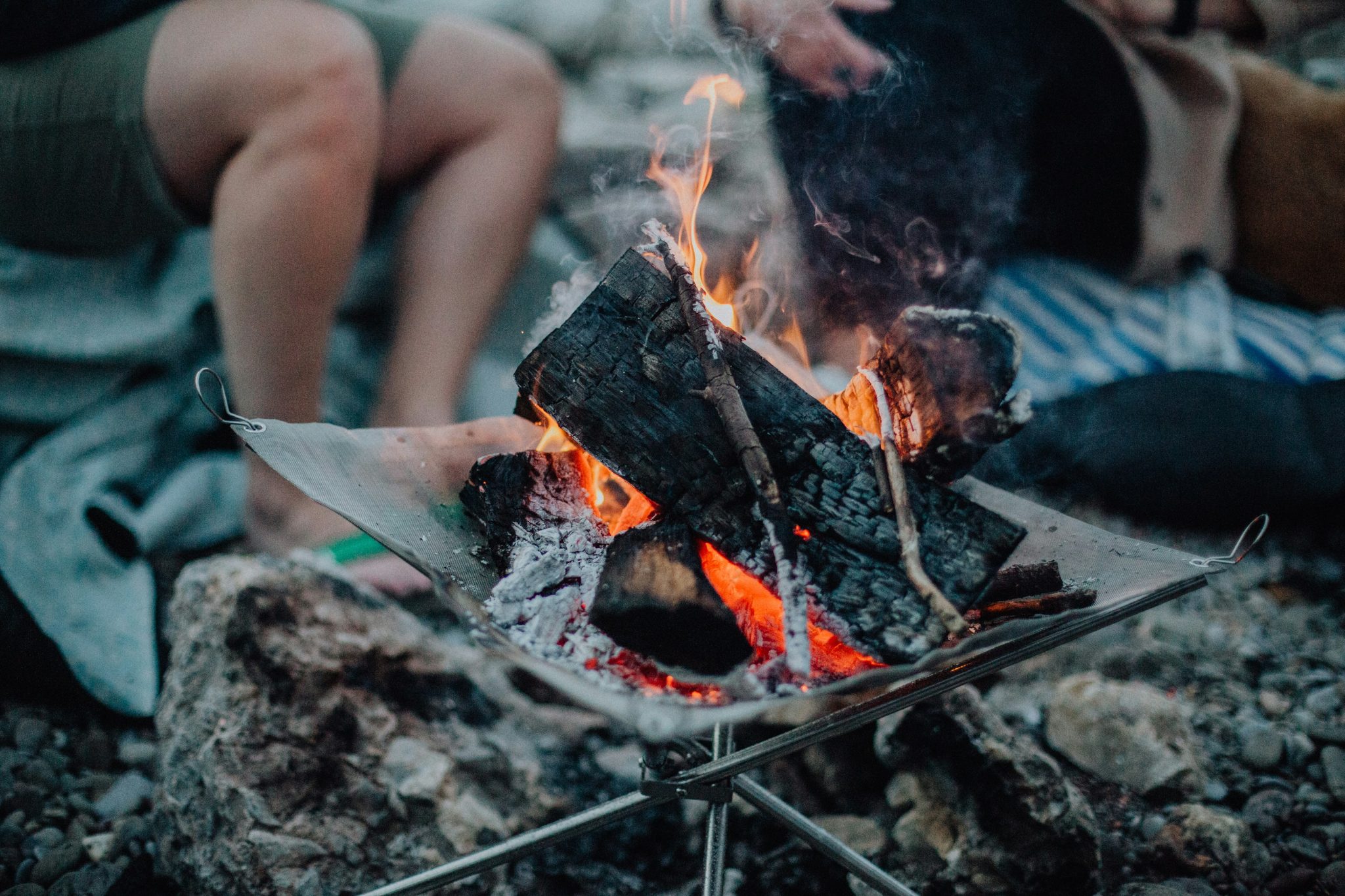 Campfire burning with people in background