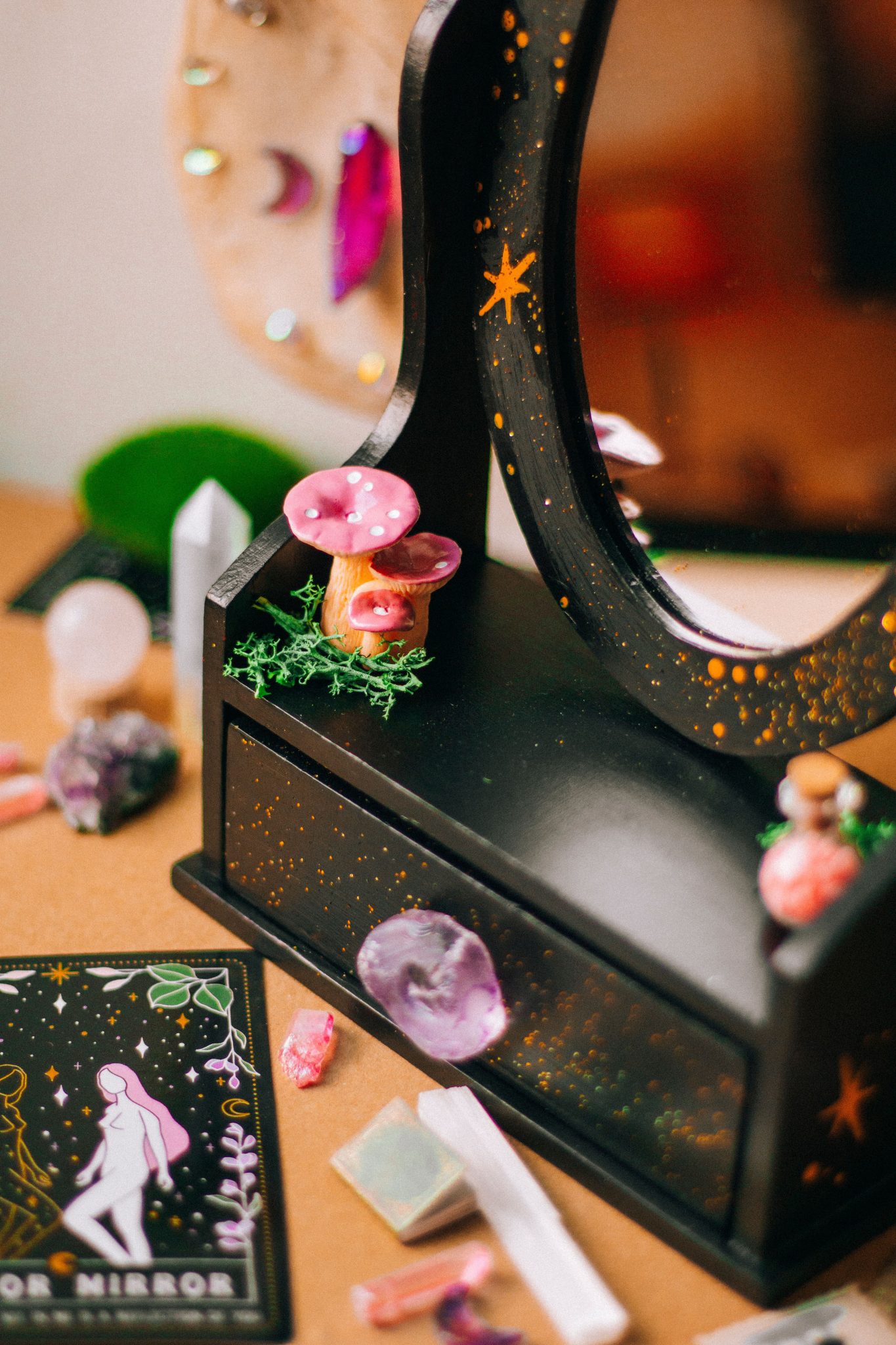 Close-up of a mystical decorative mirror adorned with crystals and mushrooms.
