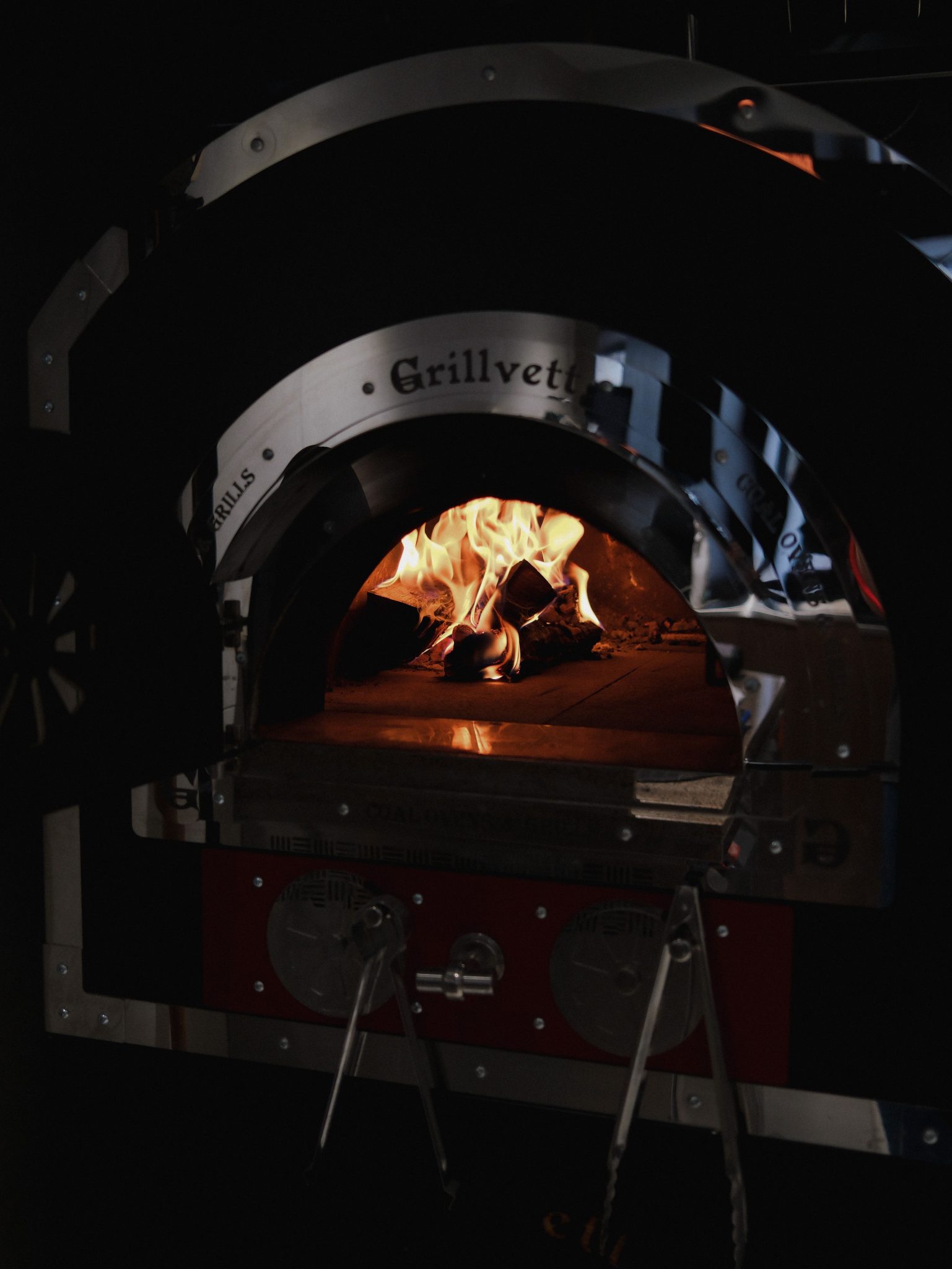 Close-up of a traditional wood-fired oven showcasing vibrant flames and a cozy atmosphere.