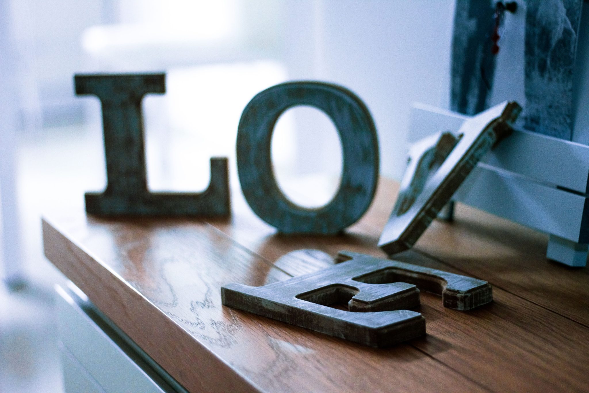 Close-up of rustic wooden letters spelling 'LOVE' on a wooden table indoors, perfect for romantic themes.