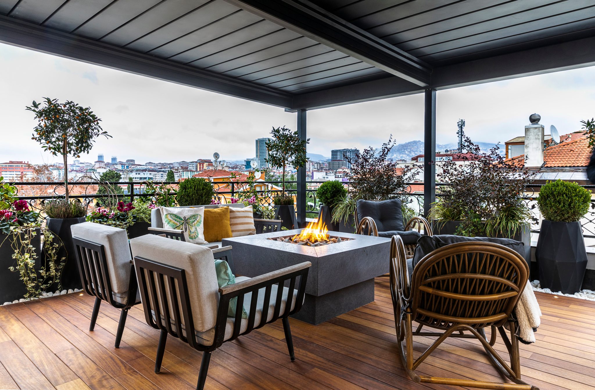 Cozy terrace with fireplace, seating, and city view. Perfect for relaxing evenings.