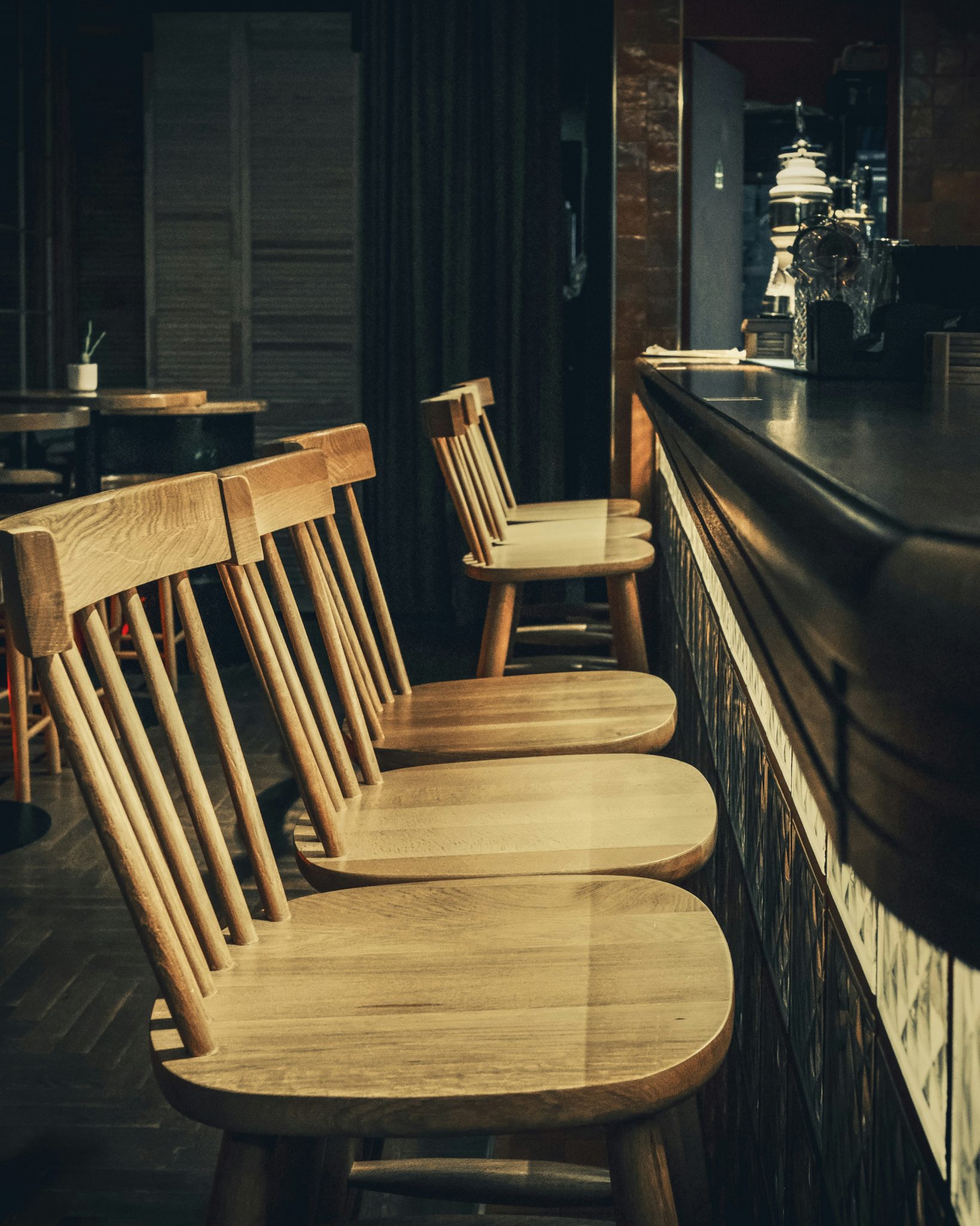 Empty wooden bar stools lined up at a counter