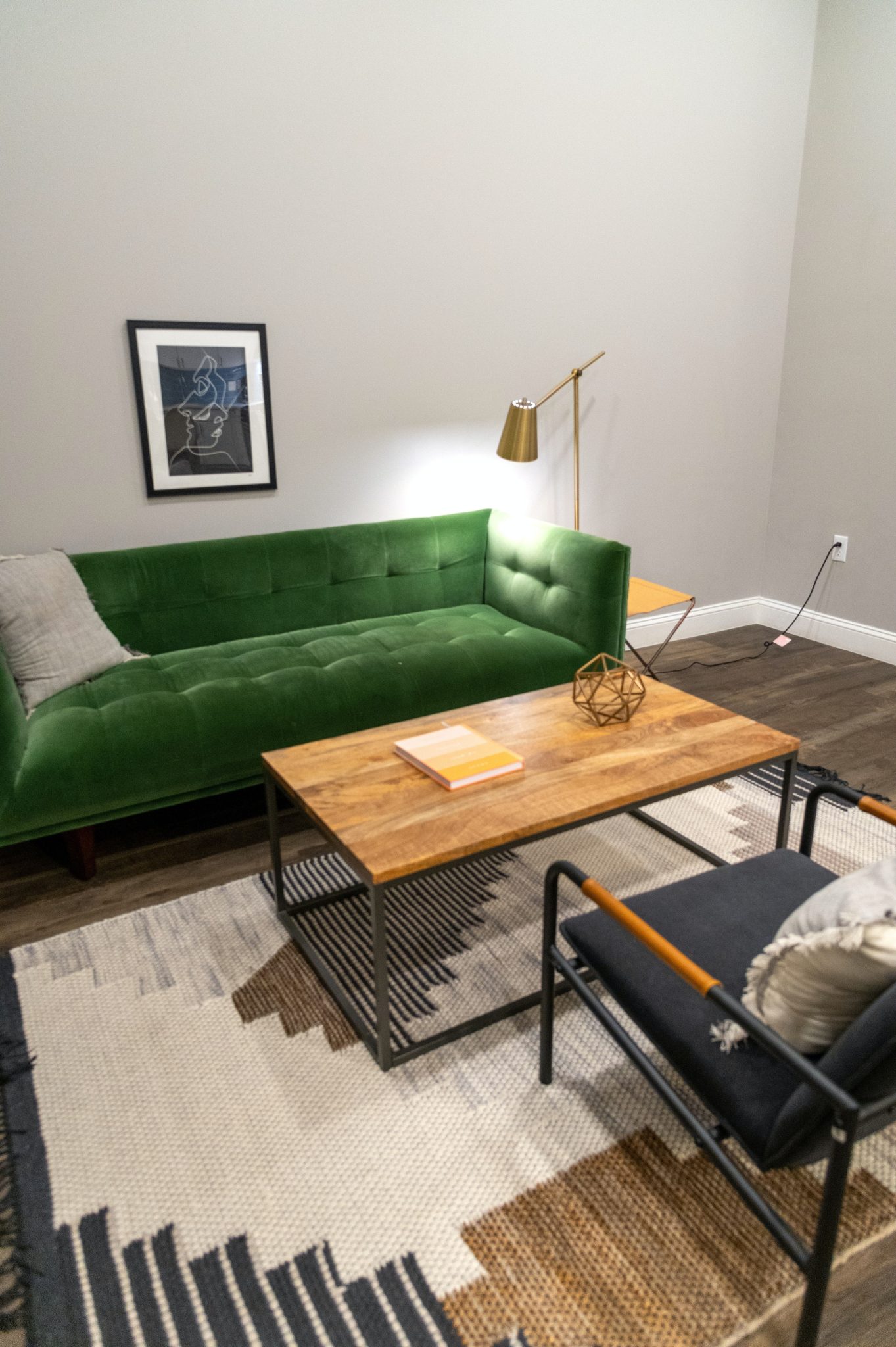From above of contemporary room interior with comfortable sofa near table on carpet and shiny lamp