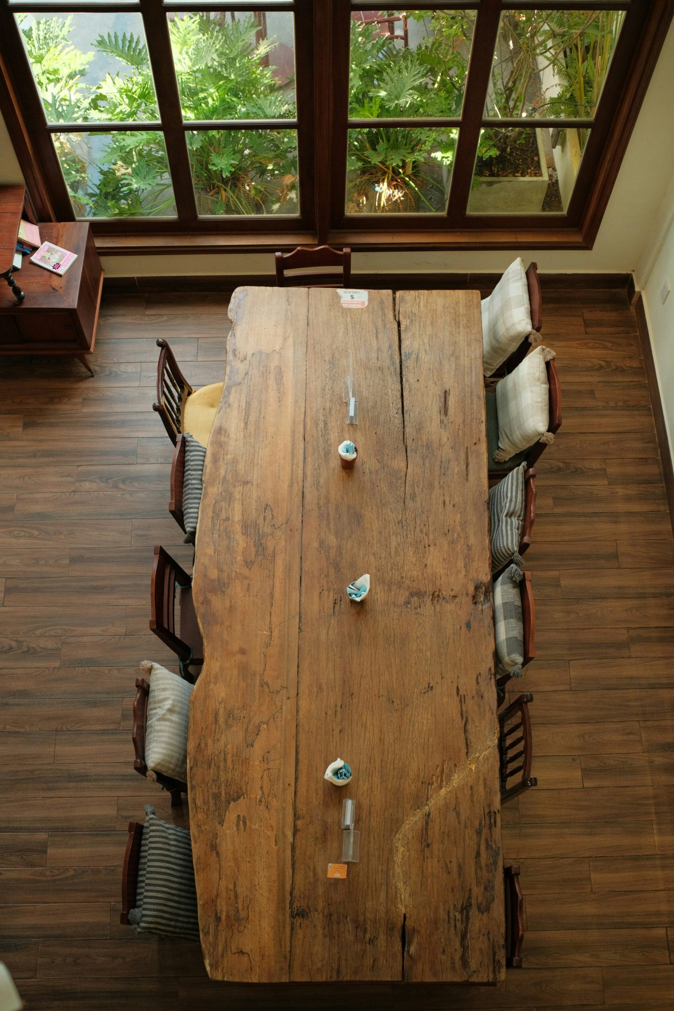 Large rustic wooden dining table with chairs viewed from above