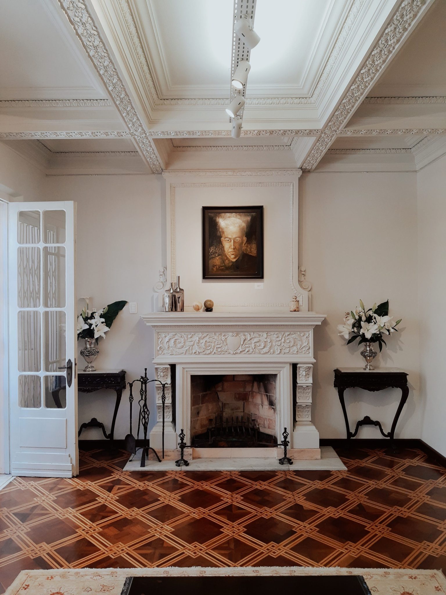 Luxurious room showcasing a classic fireplace, elegant decor, and captivating artwork.