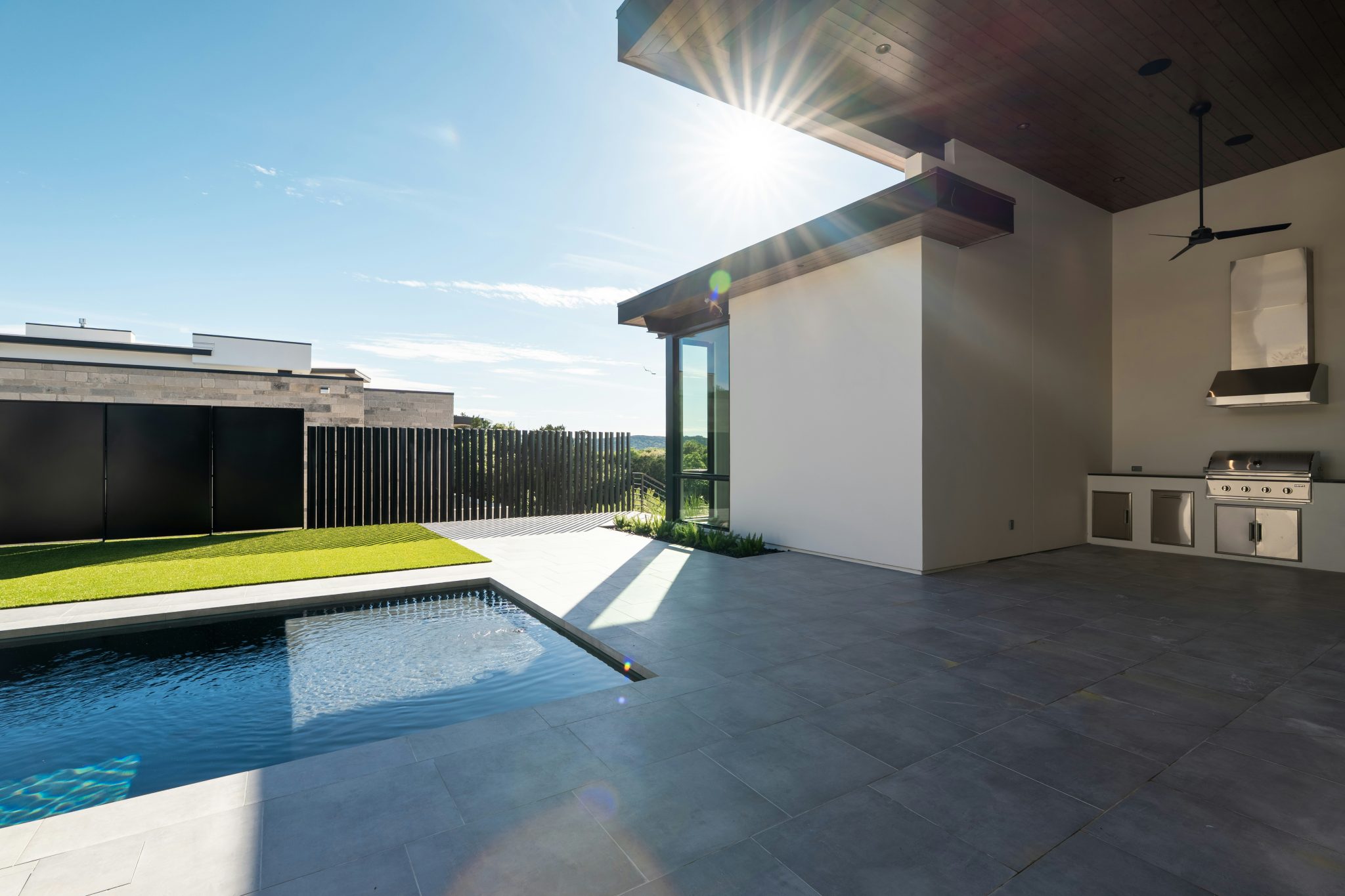 Modern outdoor patio with a swimming pool and outdoor kitchen