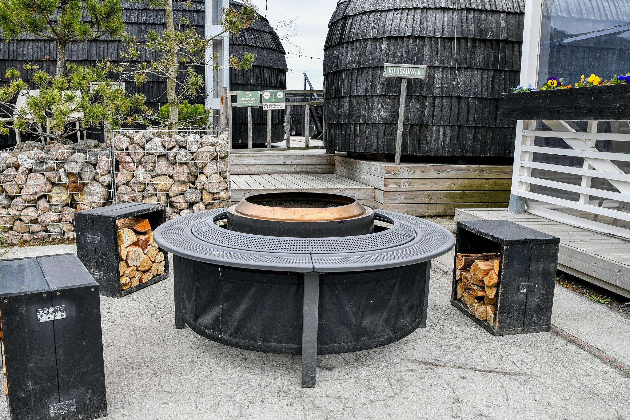 Nordic Coziness: A modern circular outdoor fire pit with stacked firewood at Iglupark in the Noblessner district of Tallinn, Estonia.