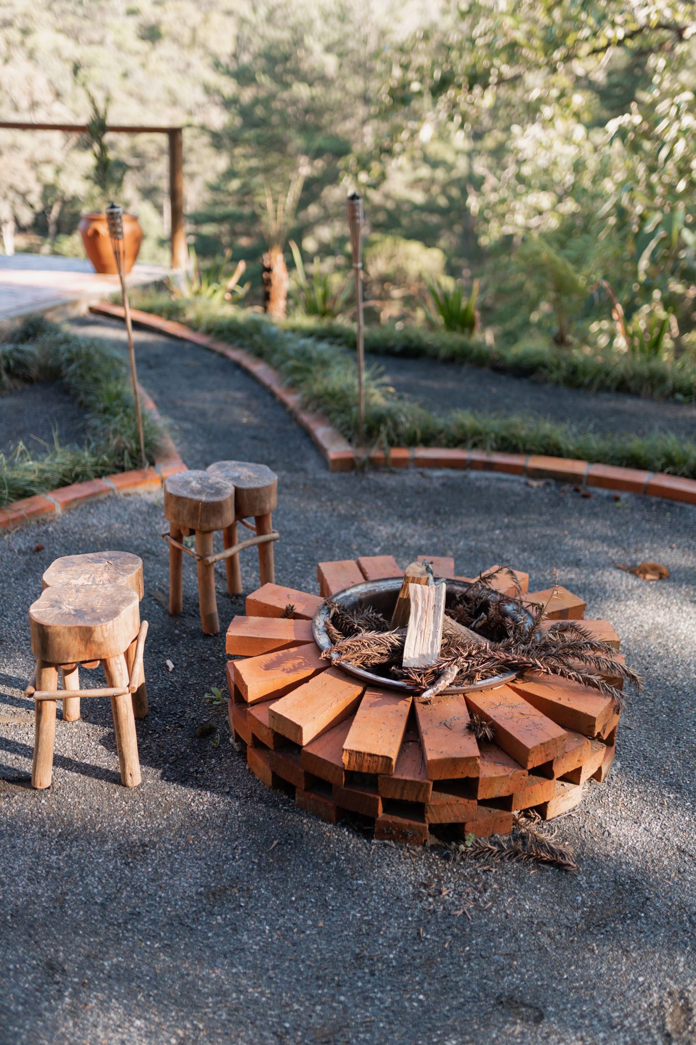 Rustic fire pit with wooden stools outdoors, ideal for nature gatherings.