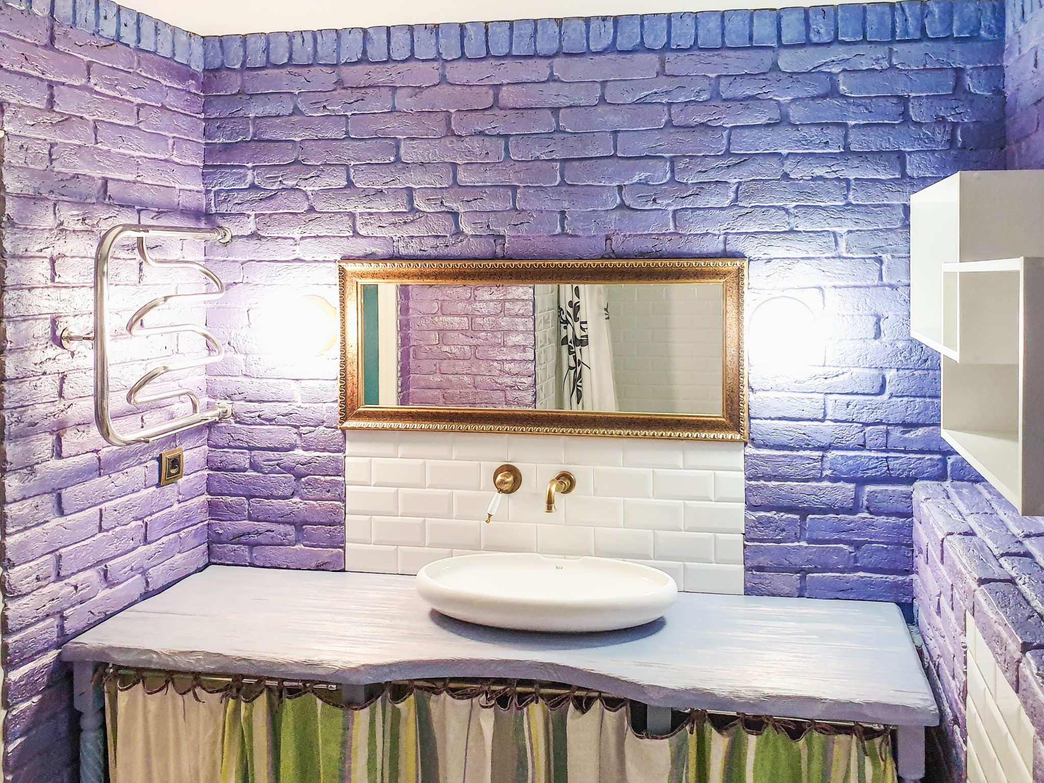 Stylish bathroom with purple brick walls, vanity sink, and elegant mirror.