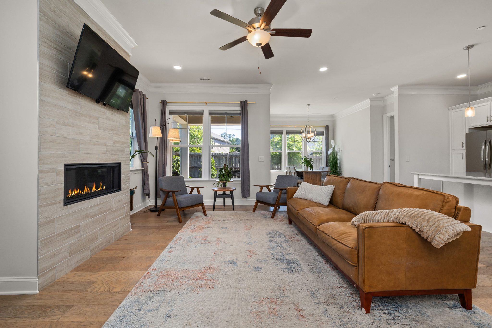 Stylish living room featuring a modern sofa, fireplace, and large windows.