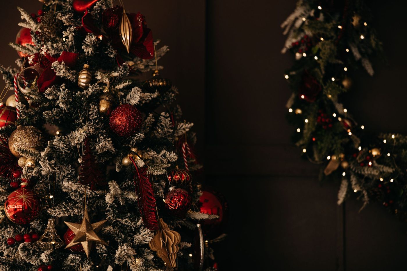 A beautifully decorated Christmas tree with red and gold ornaments under warm lighting indoors.