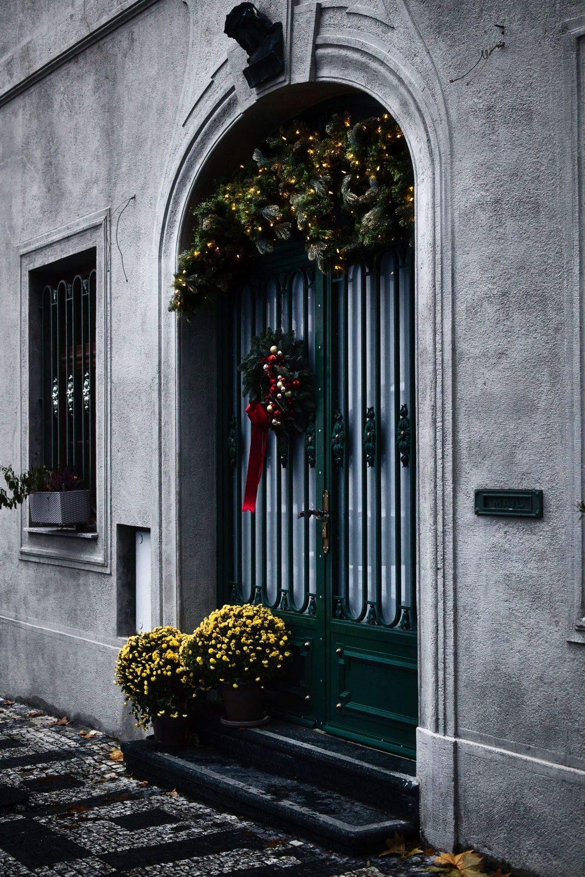 A beautifully decorated door with festive wreath, lights, and flowers, perfect for holiday inspiration.