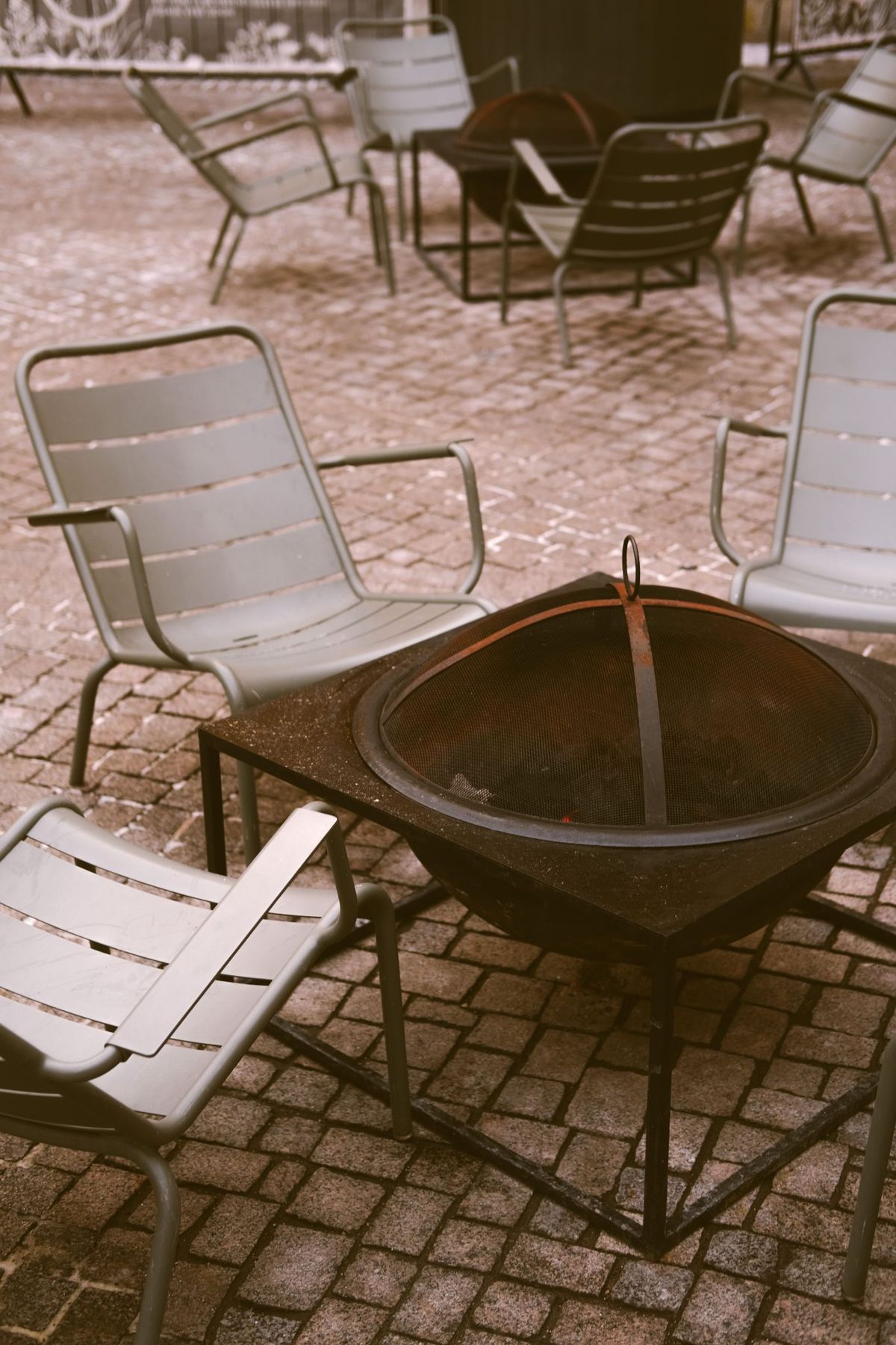 A charming outdoor patio scene featuring chairs and a central fire pit perfect for cozy gatherings.