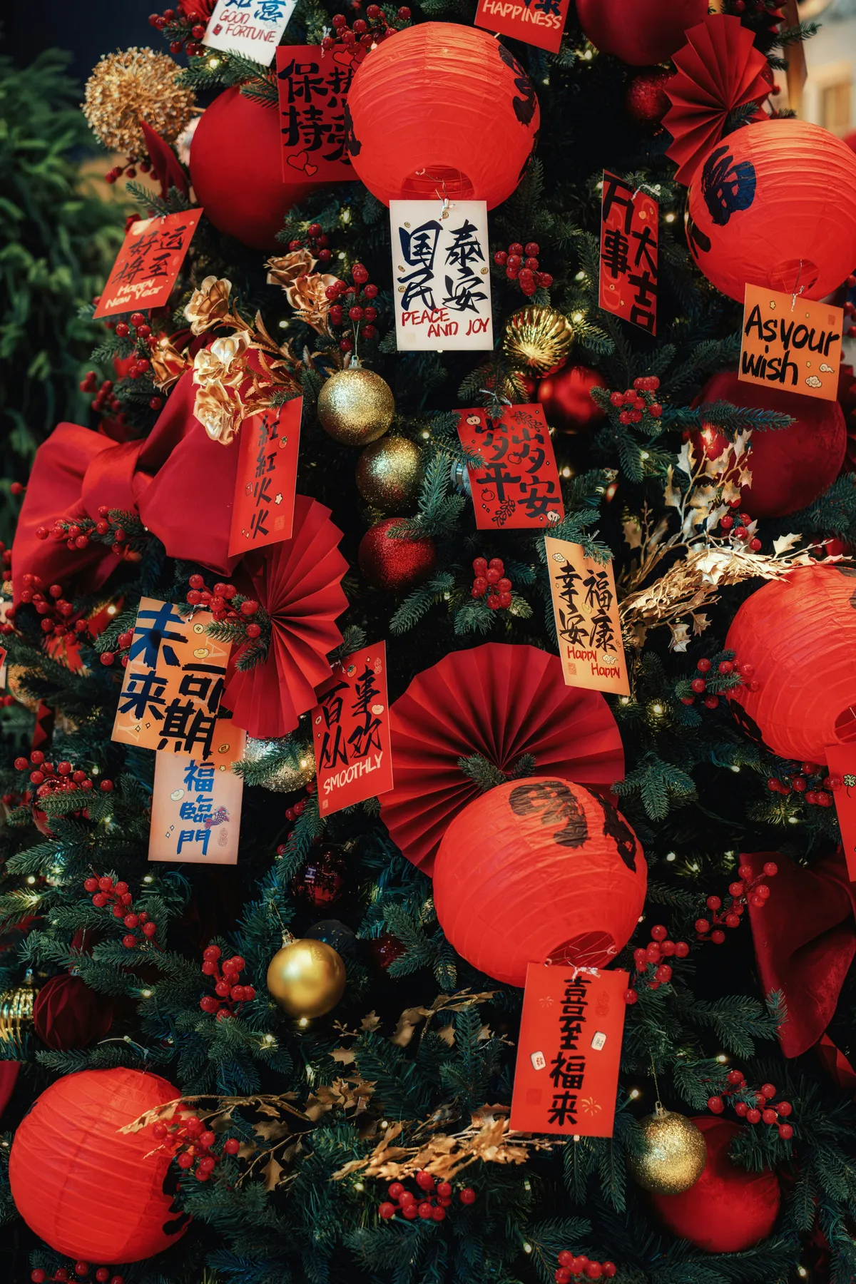 A christmas tree decorated with red lanterns and chinese calligraphy