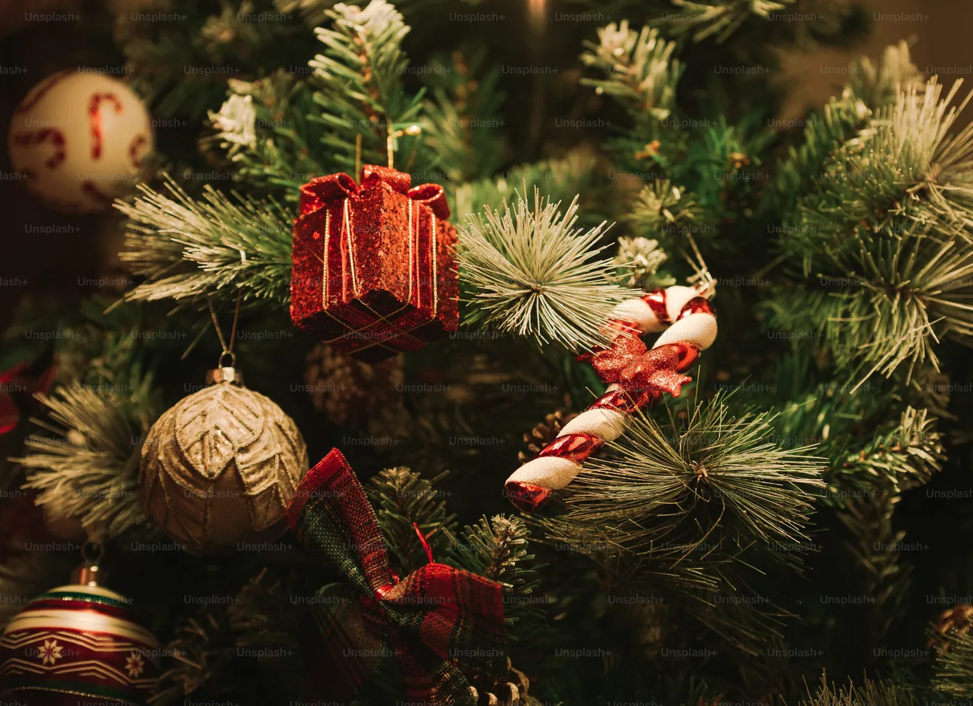 A close up of a christmas tree with ornaments - Photo on Unsplash+