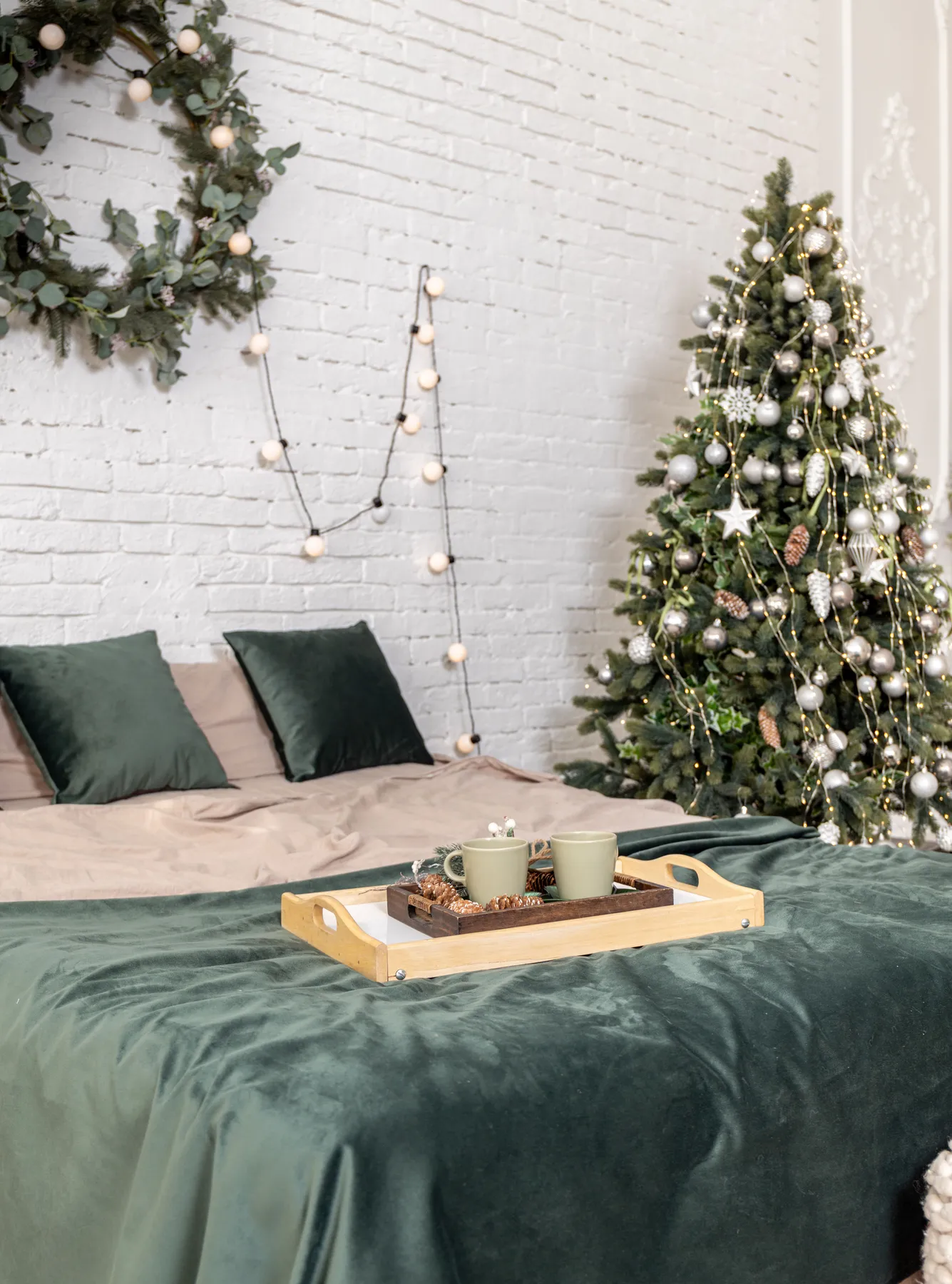 A cozy bedroom with a Christmas tree adorned with lights and decorations, enhancing festive vibes.