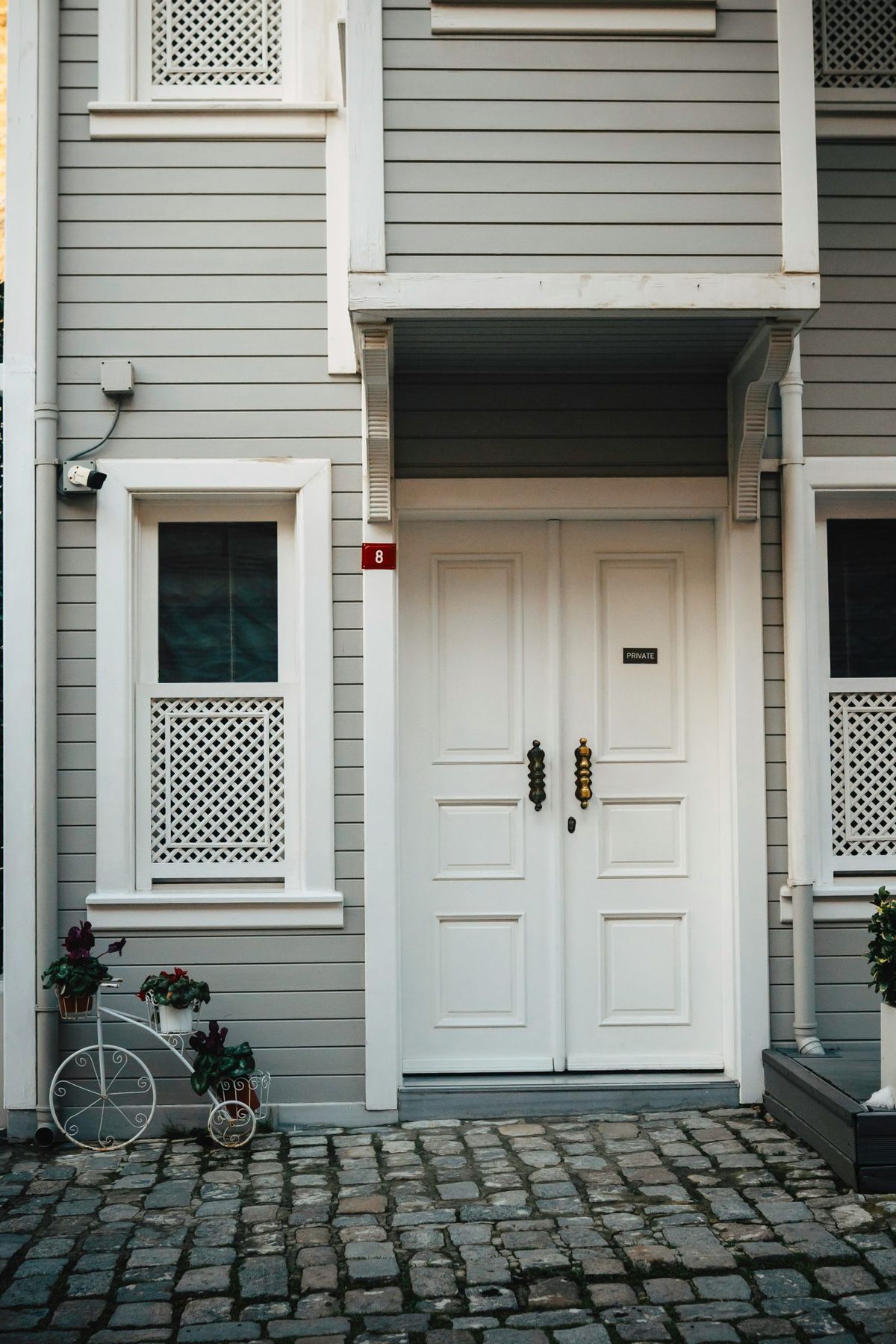 A gray house with white door and window