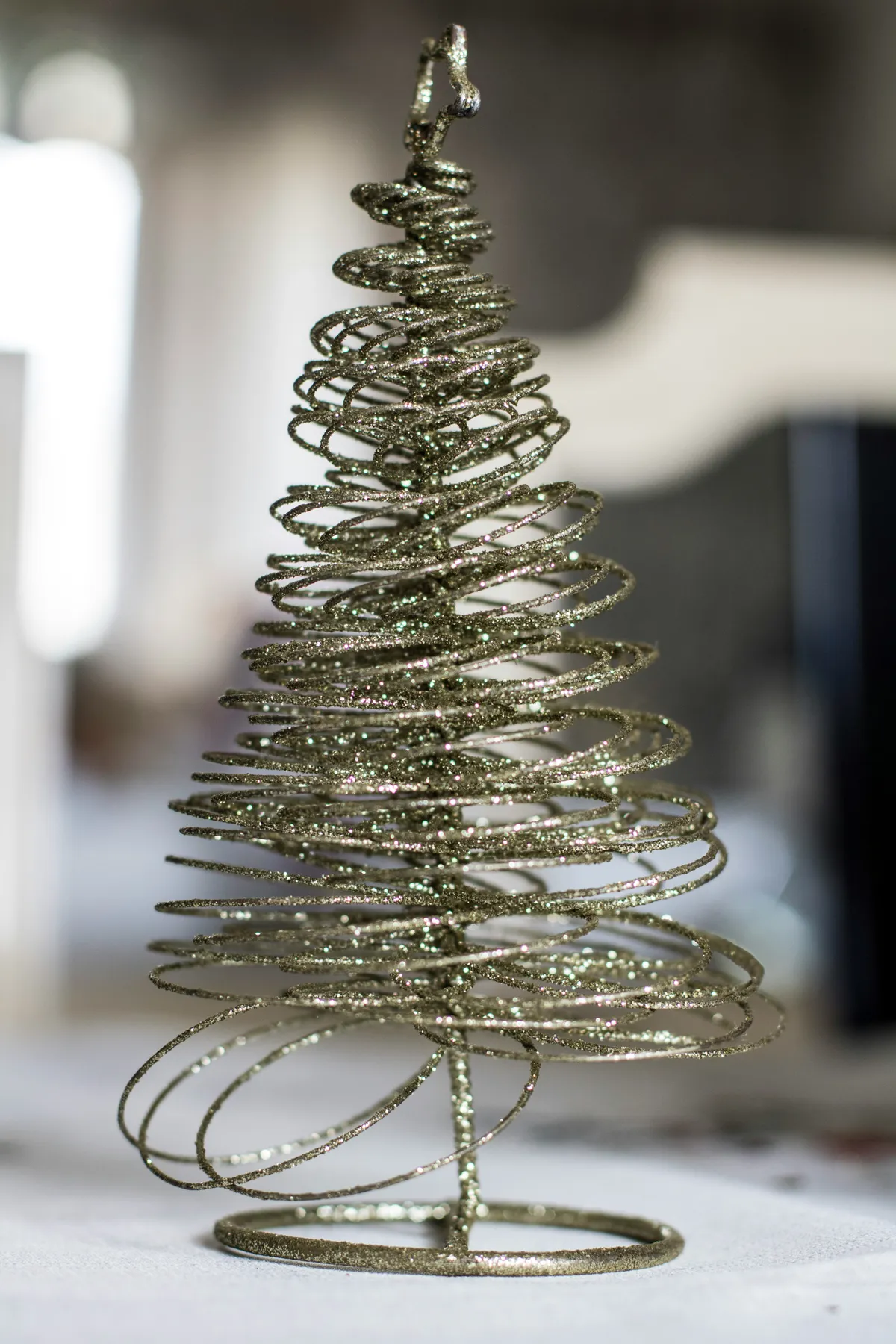A wire christmas tree sitting on top of a table