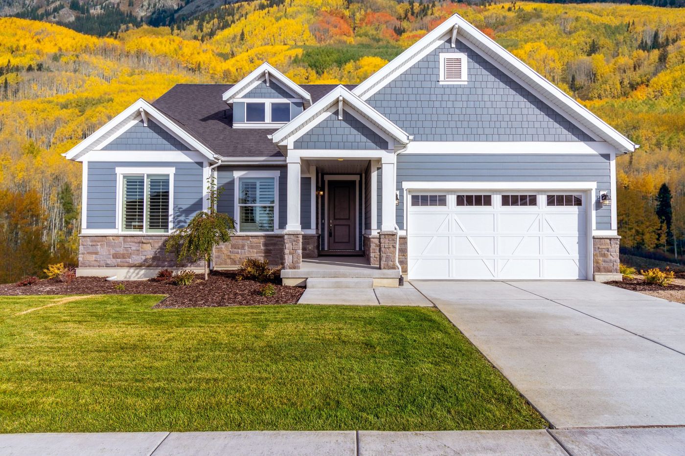 Beautiful suburban house with vibrant autumn foliage backdrop.
