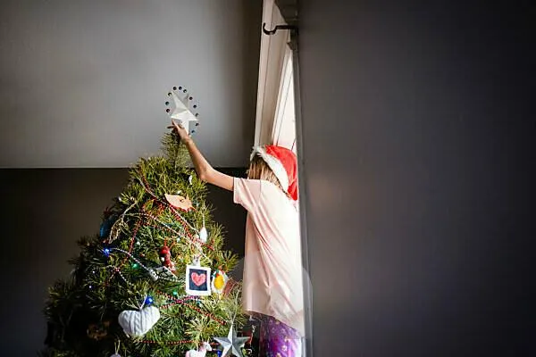 Bildagentur | mauritius images | Low angle view of girl decorating Christmas tree at home