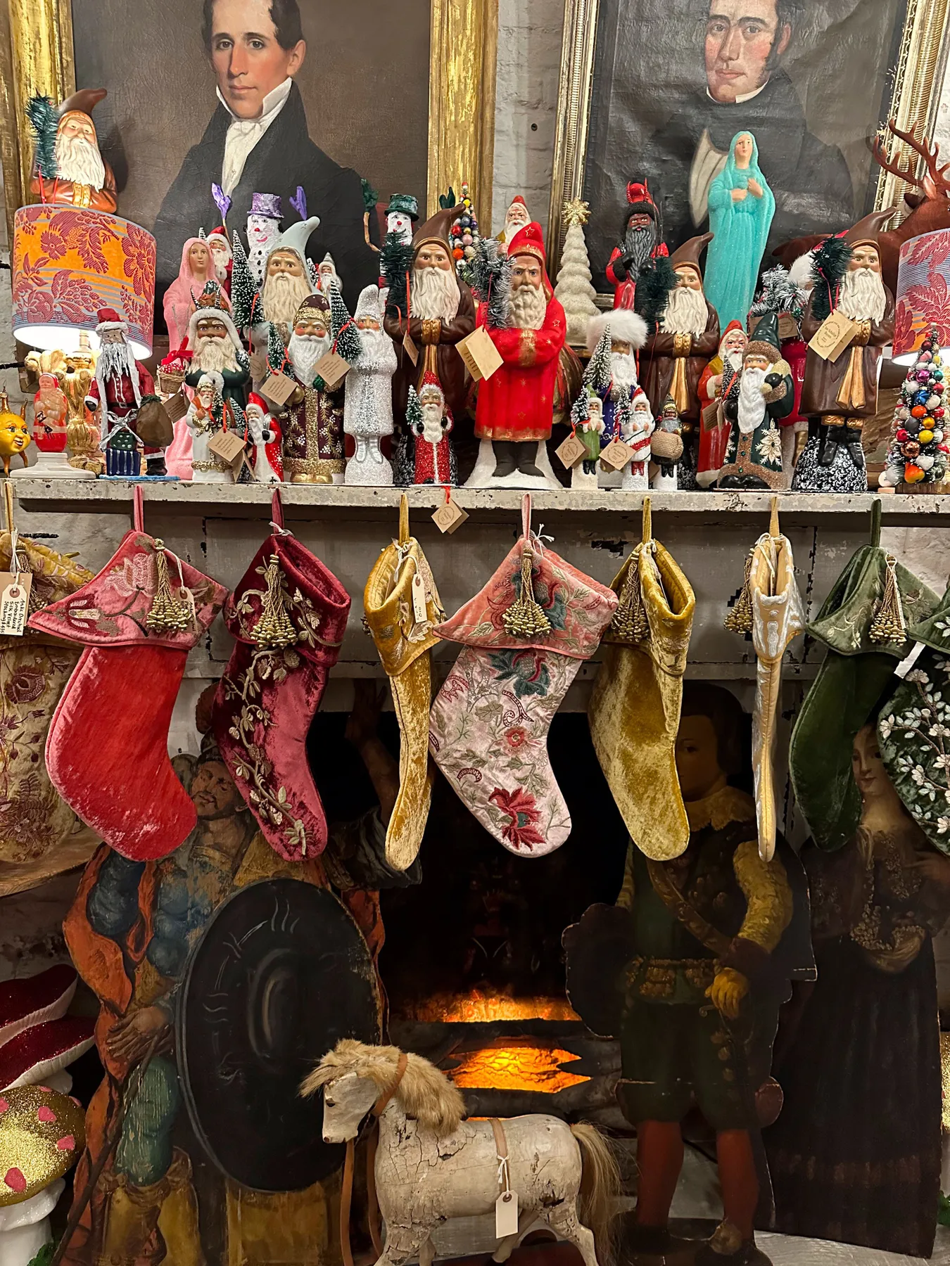 Charming Christmas scene with vintage stockings and Santa Claus figurines on a mantel.