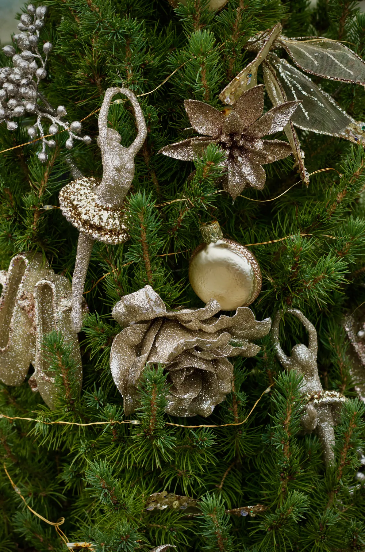 Christmas tree adorned with gold ballet dancer and flower ornaments, embodying festive elegance.