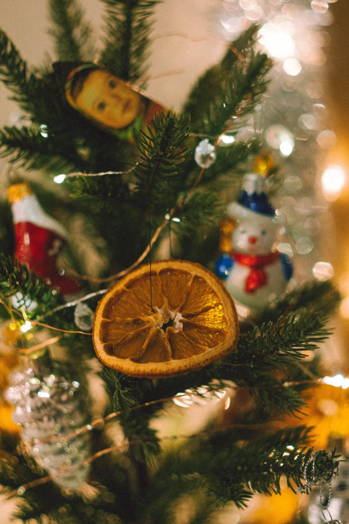 Close-up of a decorated Christmas tree with an orange slice and festive ornaments.