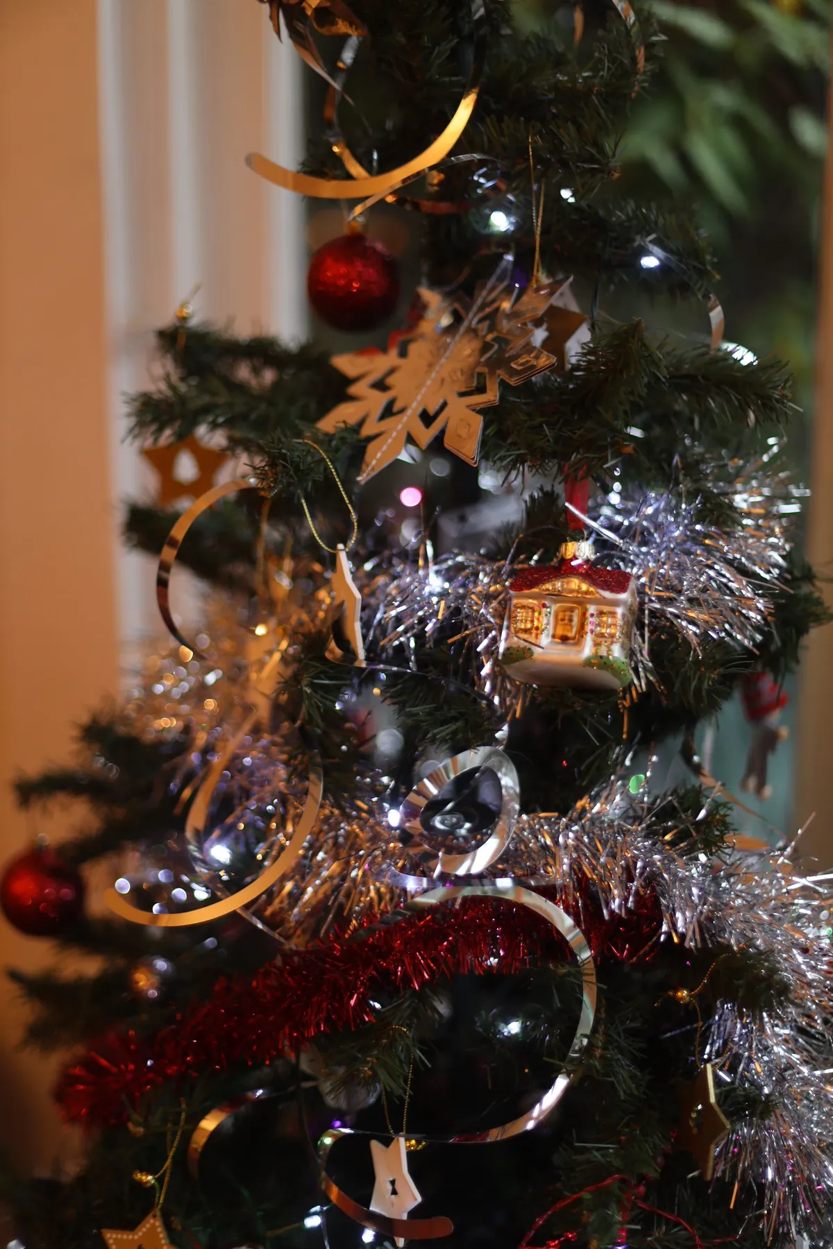 Close-up of a decorated Christmas tree with ornaments and tinsel, perfect for holiday scenes.
