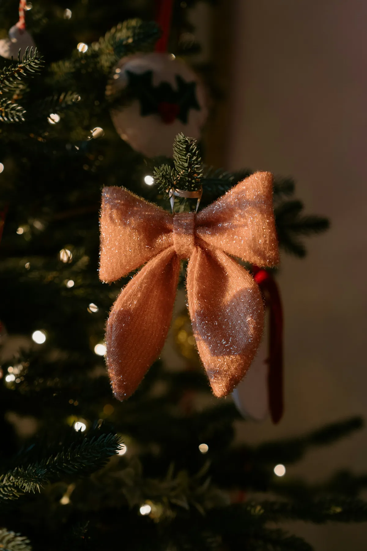 Close-up of a festive bow ornament on a christmas tree