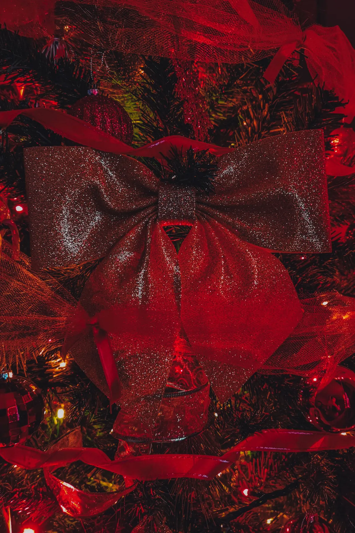 Close-up of a glittering red bow on a festive Christmas tree in Istanbul.