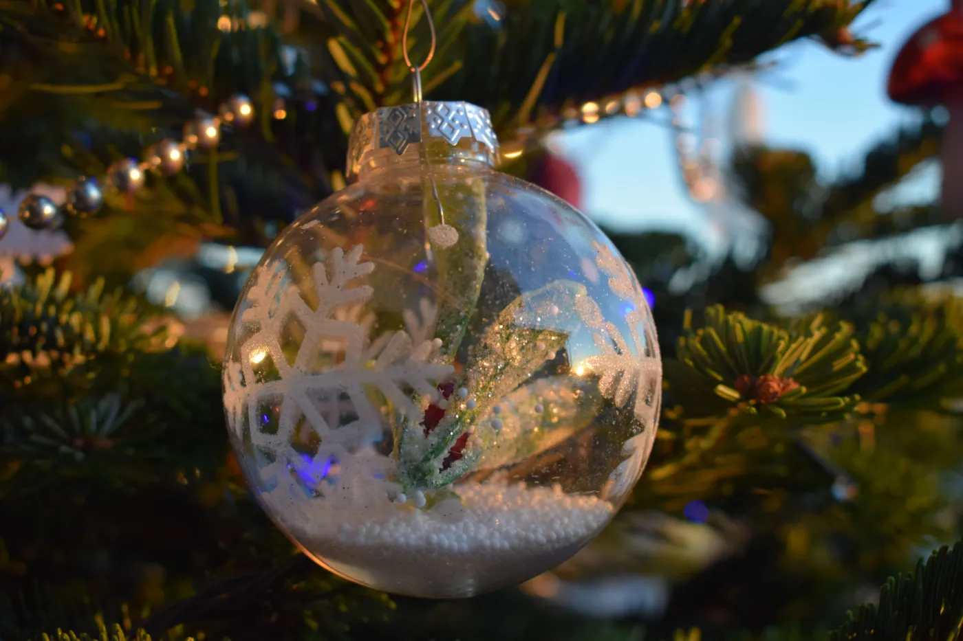 Close-up of a shiny Christmas ornament on a tree, symbolizing holiday tradition and winter celebration.