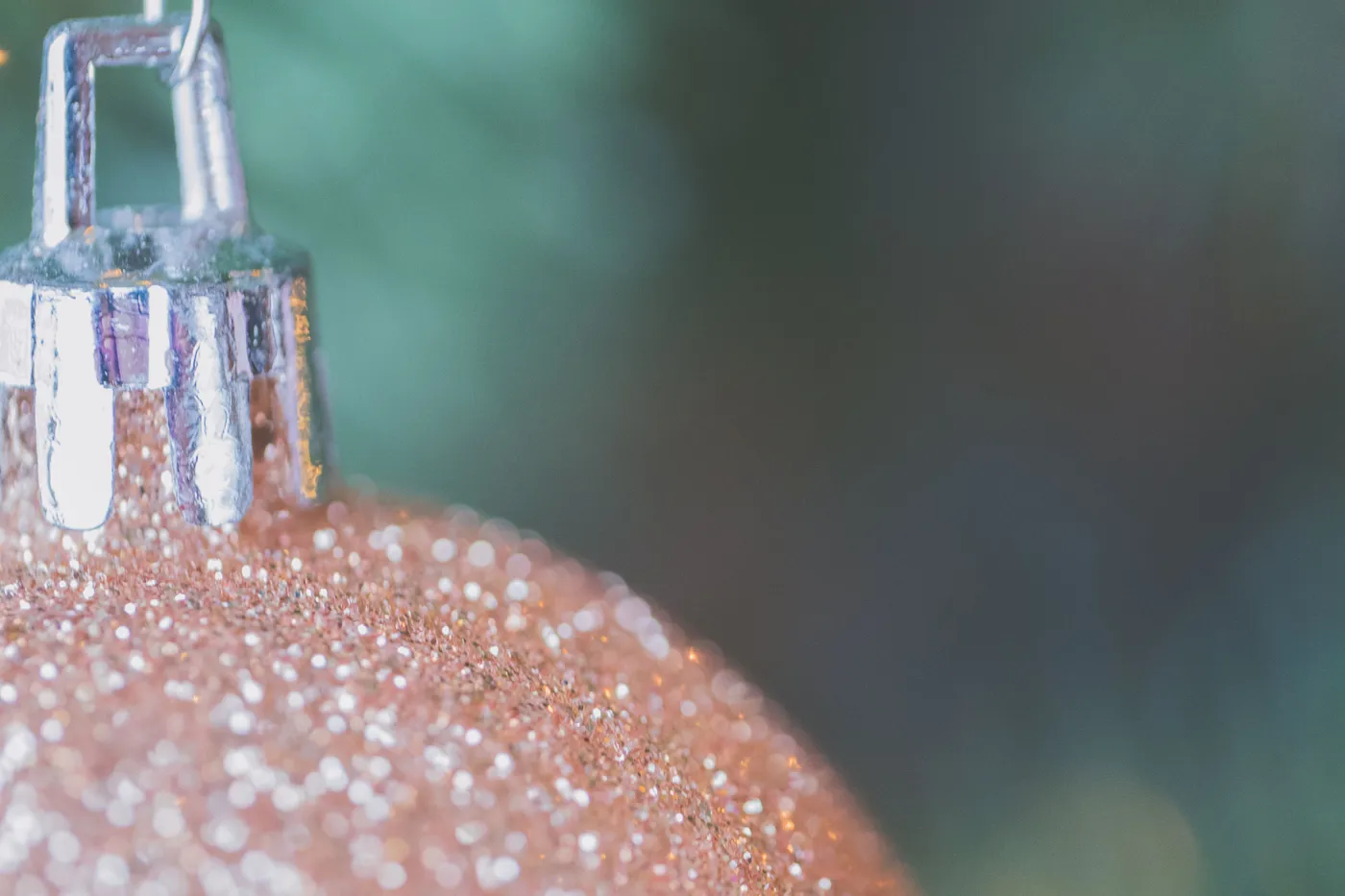 Close-up of a sparkling Christmas bauble featuring gold glitter and soft bokeh.