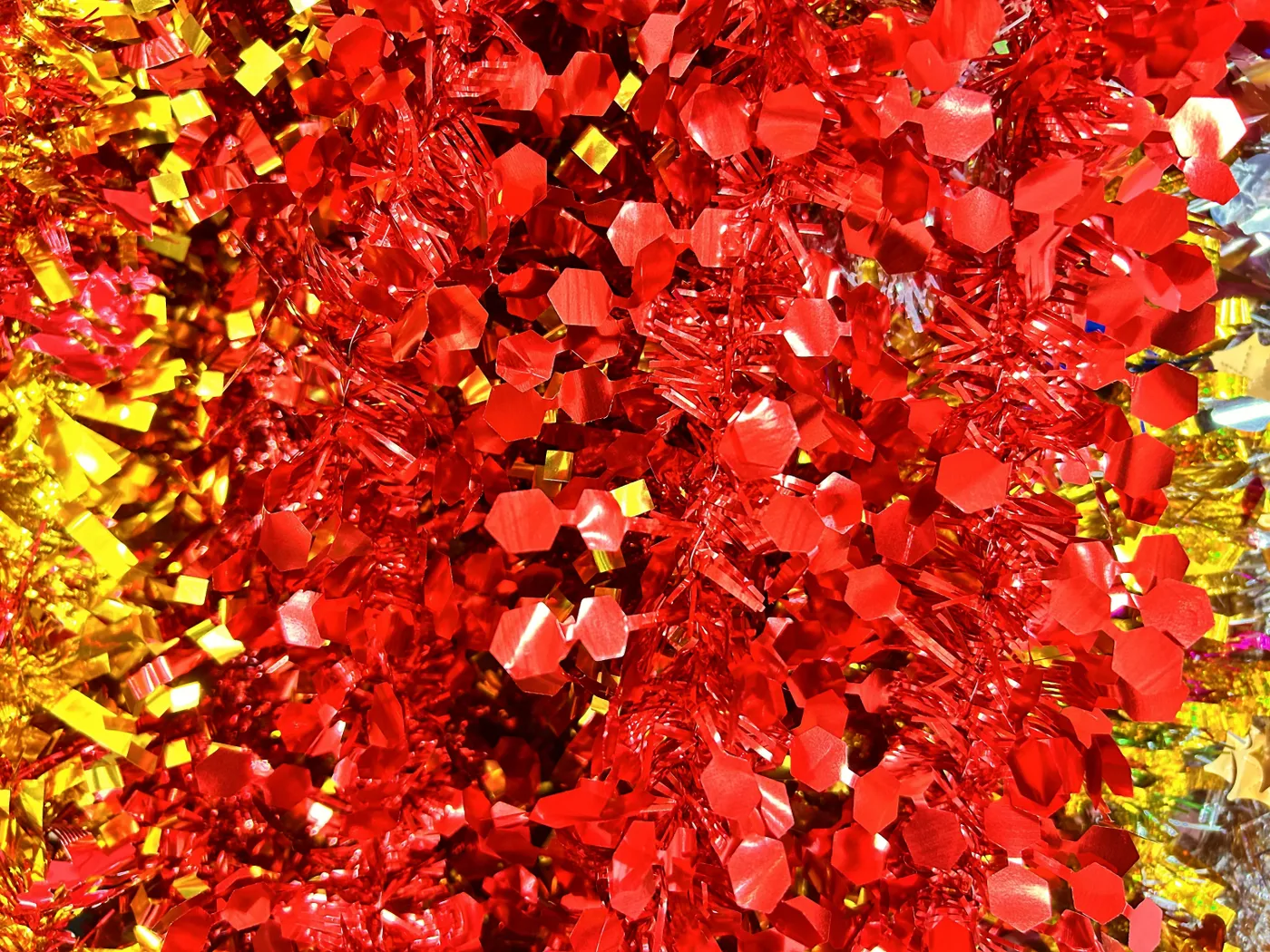 Close-up of vibrant red and gold tinsel decorations, perfect for festive celebrations.