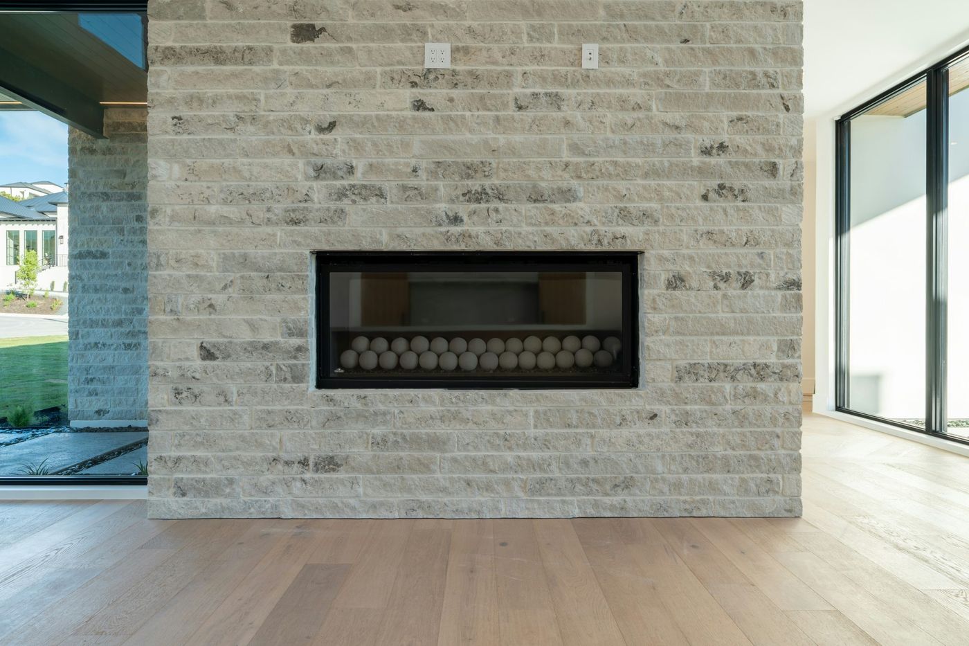 Contemporary fireplace built into a light brick wall