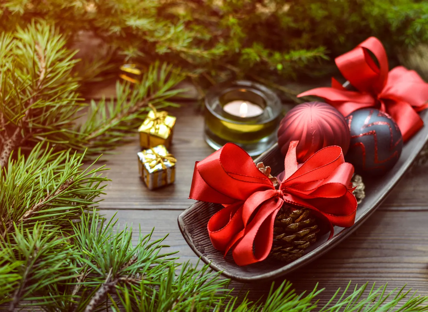 Cozy Christmas arrangement with pine, candles, and ornaments.