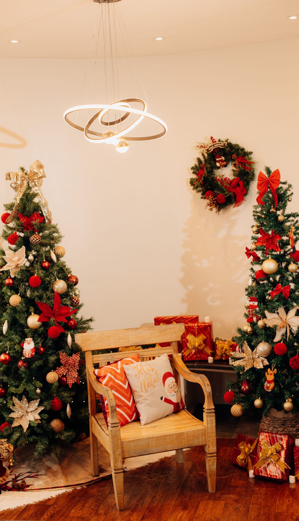 Cozy Christmas living room decor with festive trees and gifts.
