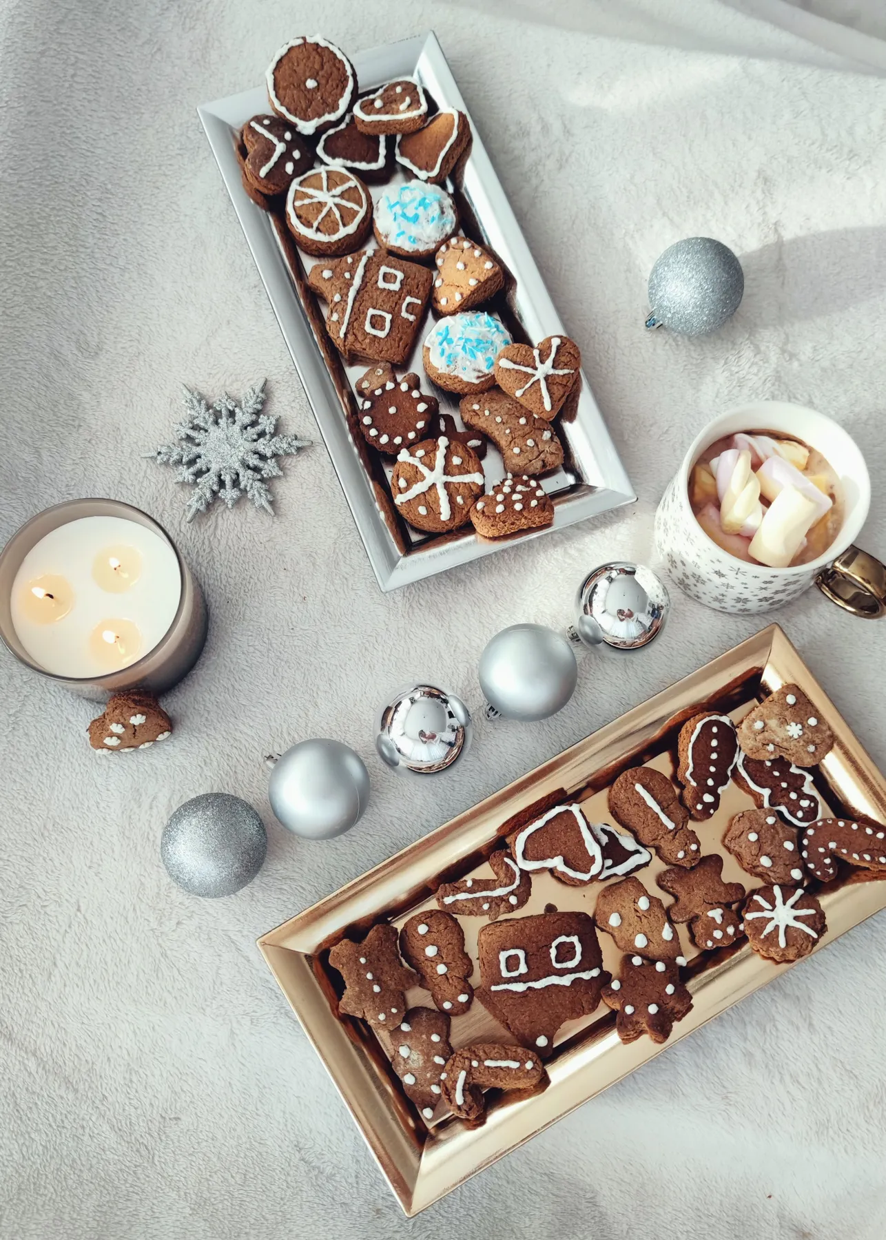 Cozy Christmas scene with gingerbread cookies, ornaments, and a mug of hot chocolate.
