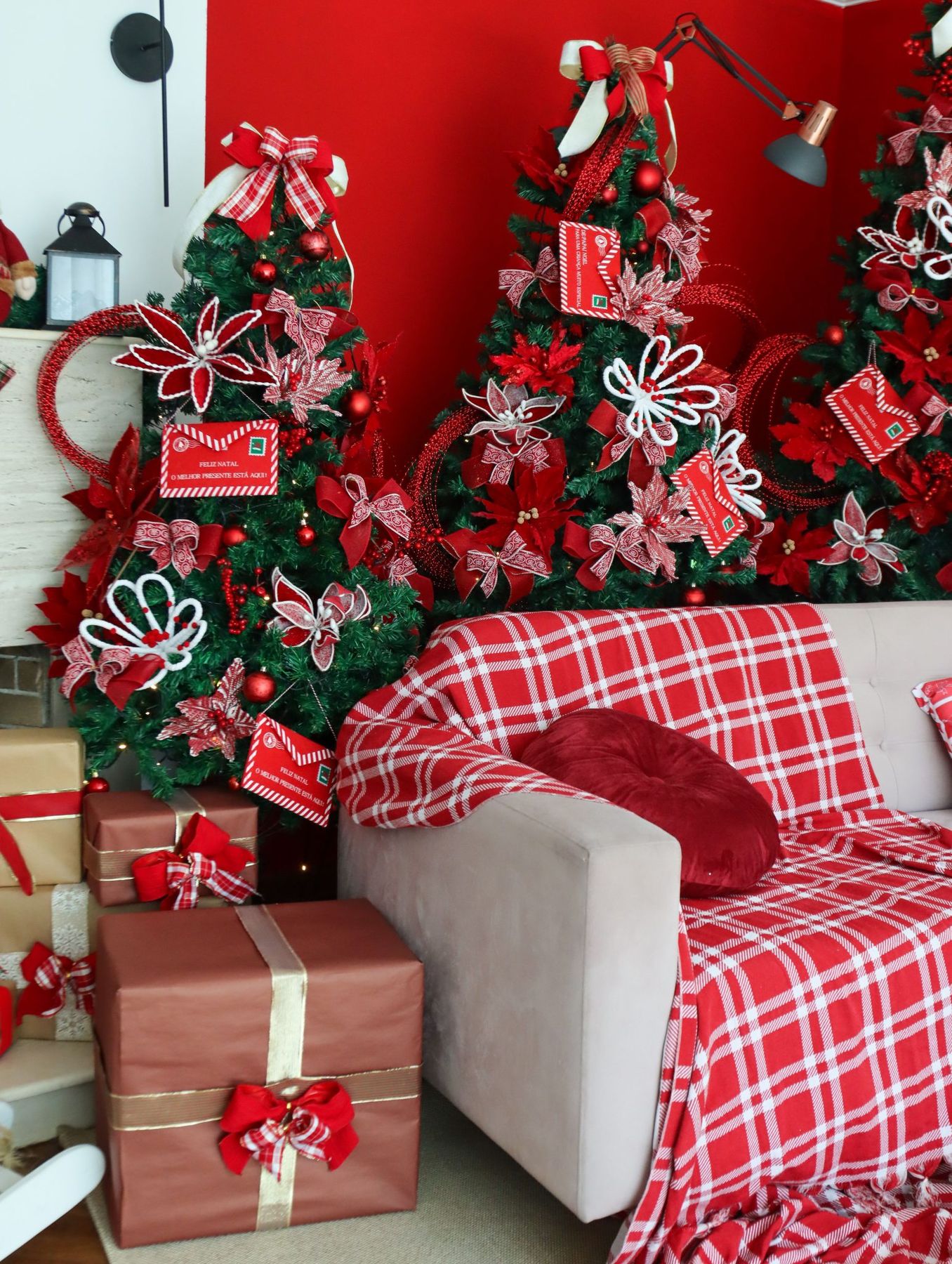 Cozy living room with Christmas trees and red plaid accents creates a warm festive atmosphere.