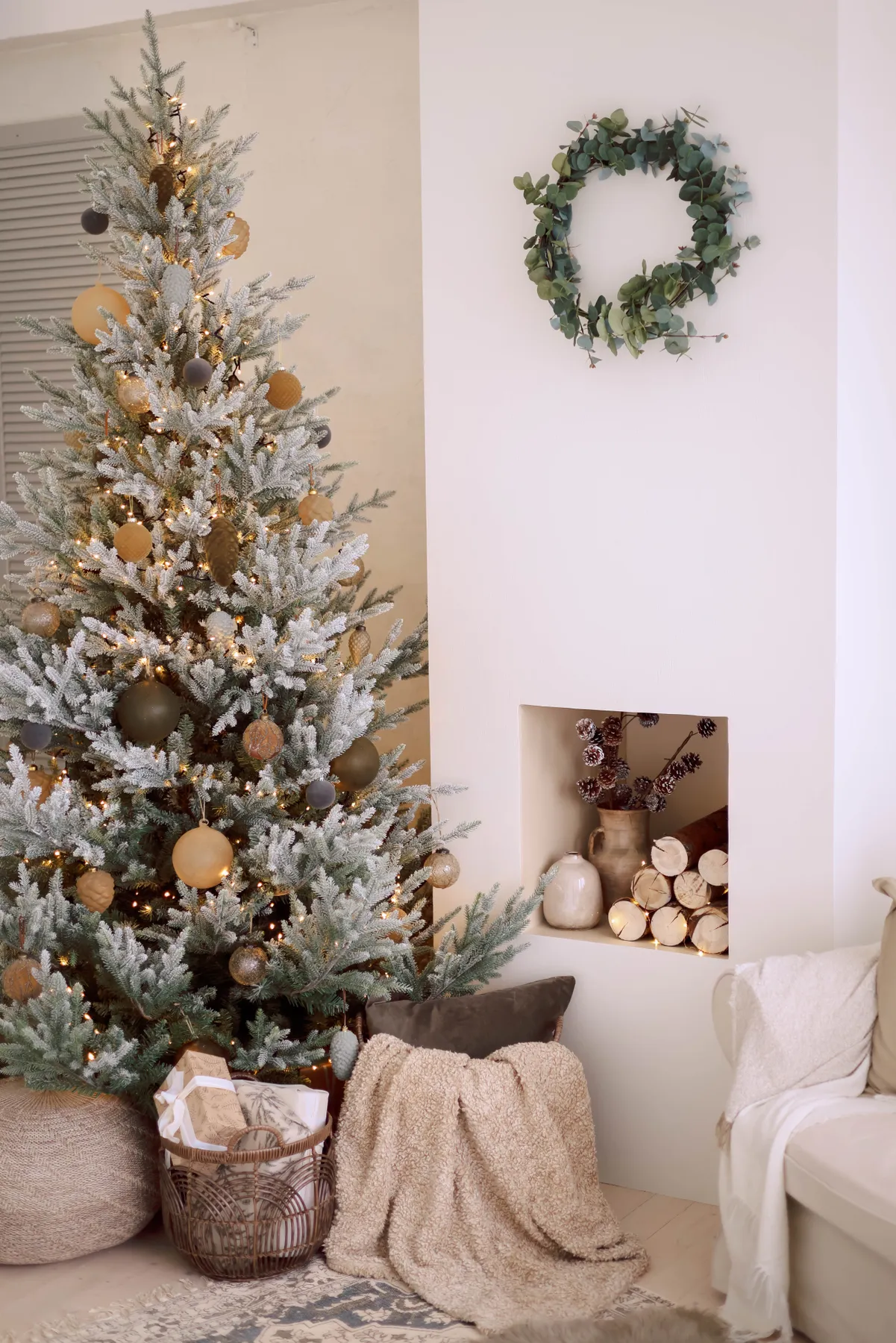 Cozy minimalist room with a decorated Christmas tree and festive wreath.