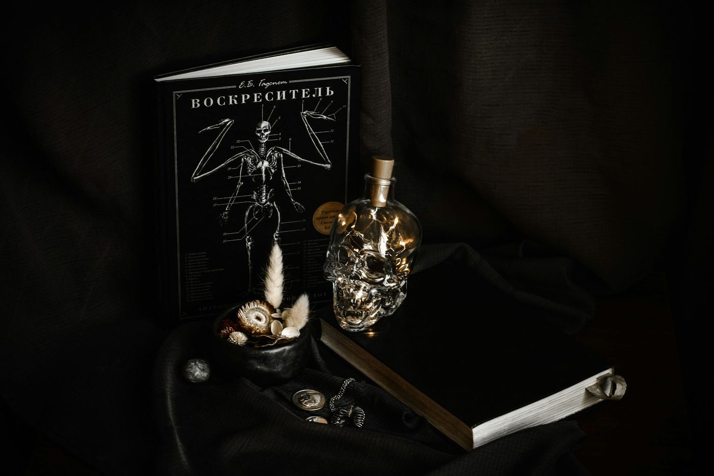 Dark still life with skull bottle and books