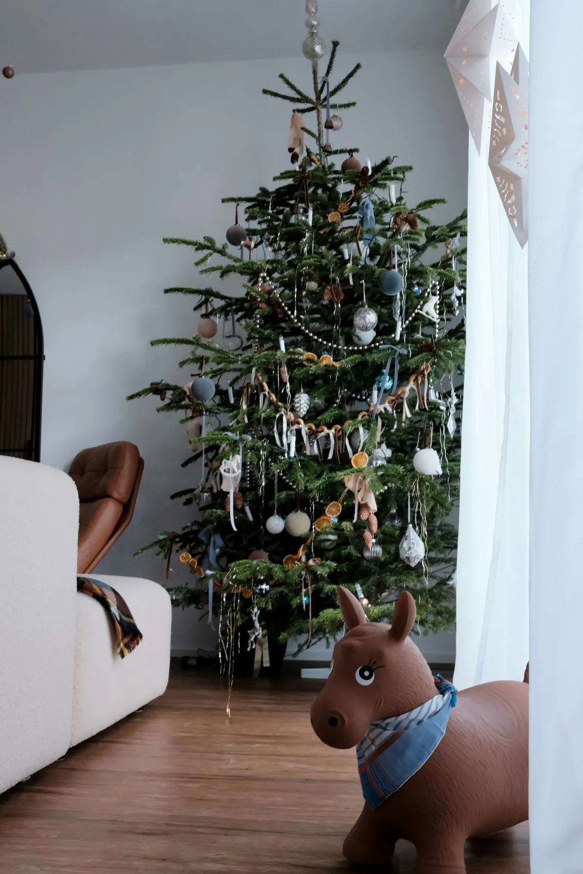 Decorated christmas tree with ornaments and a toy horse