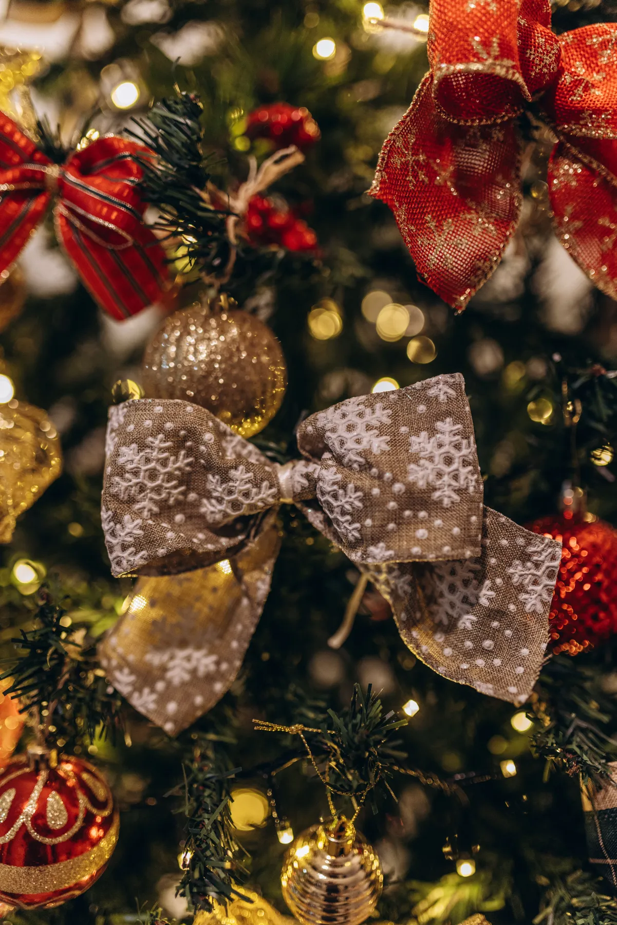 Detailed ornaments and ribbons on a Christmas tree, creating a festive ambiance.