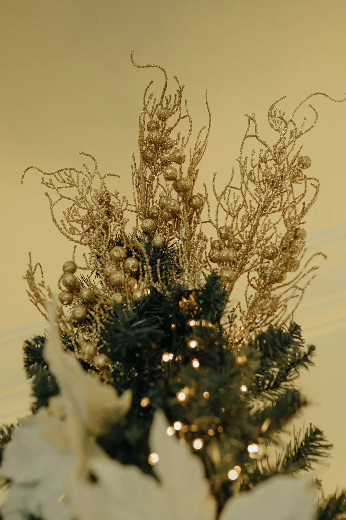 Elegant Christmas tree adorned with shimmering gold ornaments and lights, capturing a warm festive ambiance.