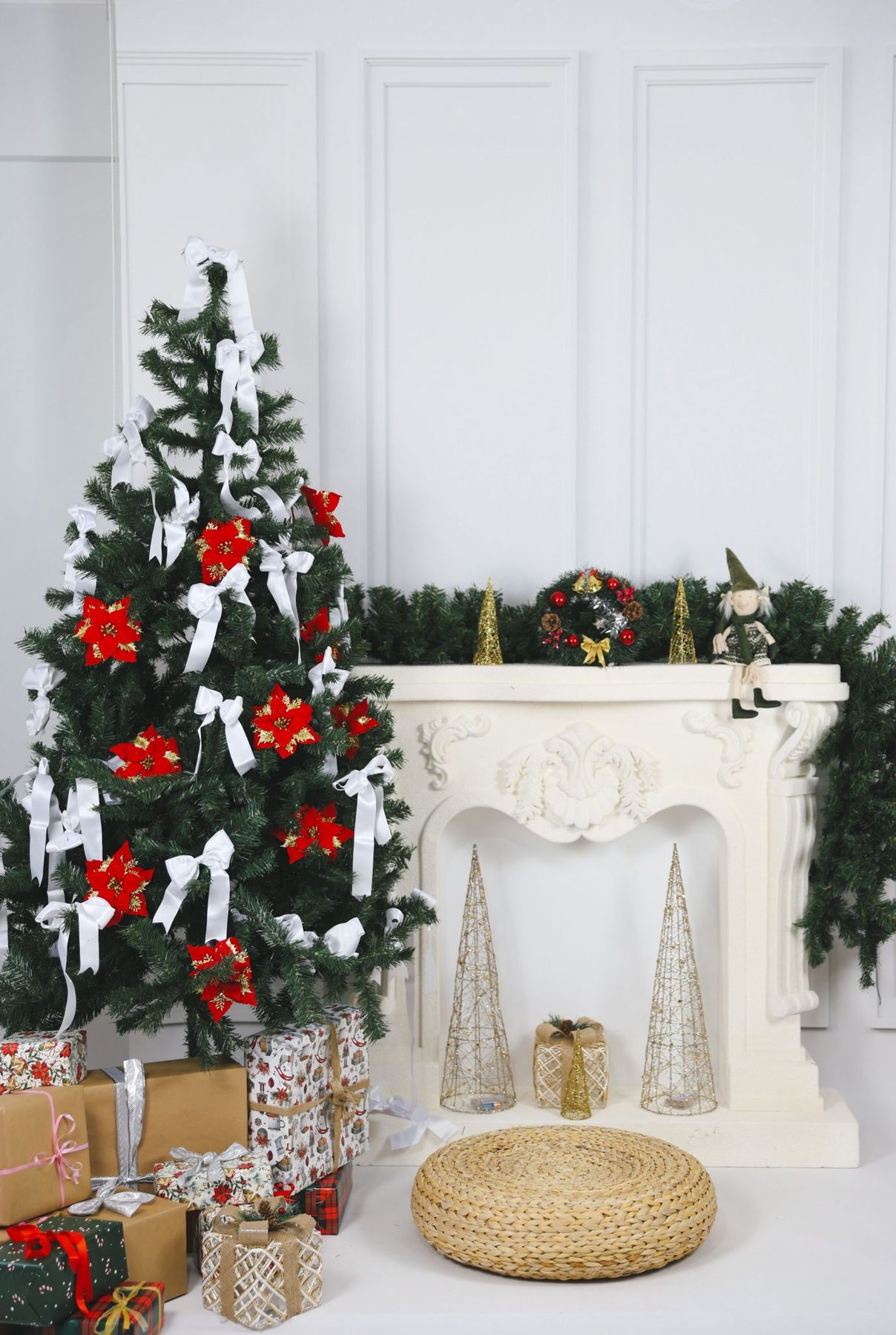 Elegant Christmas tree with gifts and fireplace in festive living room setting.