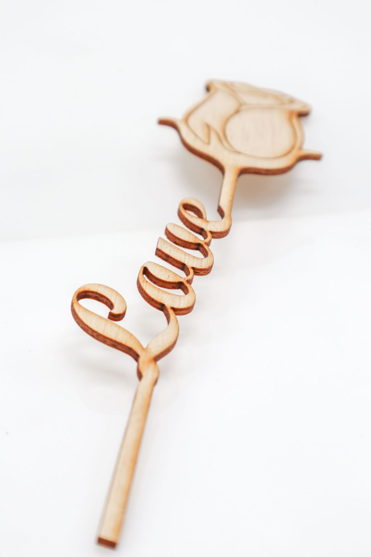 Elegant wooden stick with rose design spelling 'Love' in a script style.
