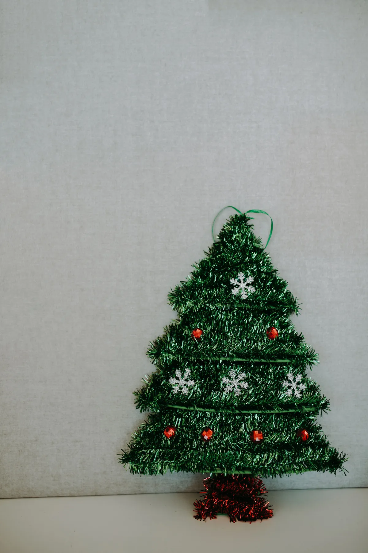 Festive Christmas tree with snowflakes on a neutral background.