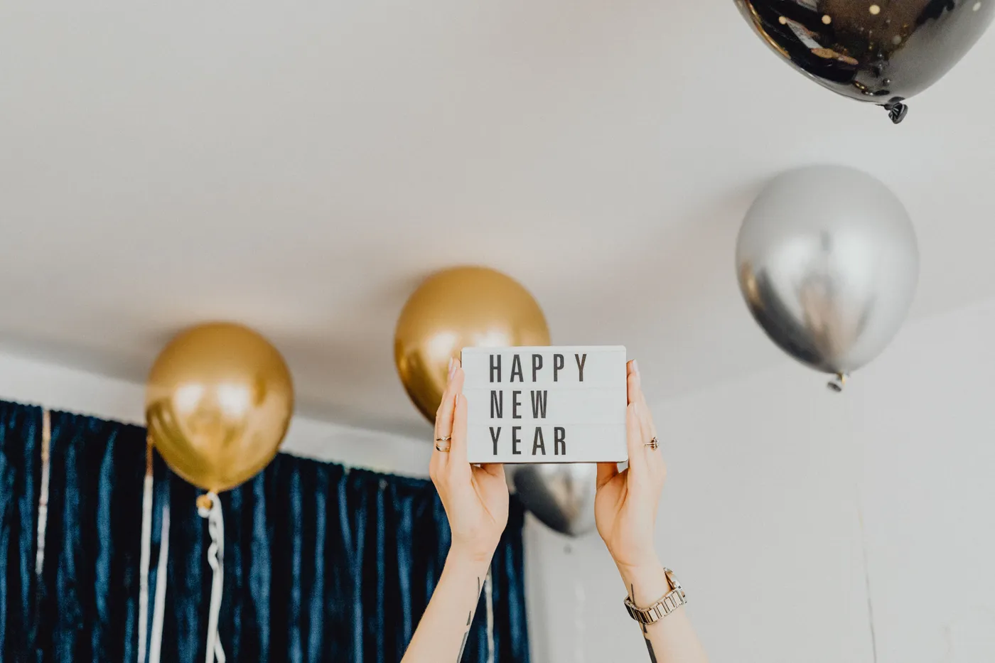 Festive New Year party with balloons and sign, celebrating the holiday season.